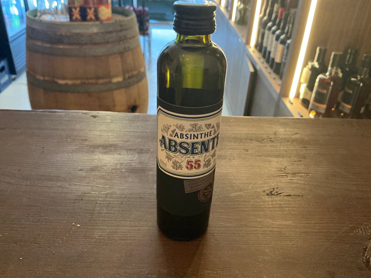 Small 10ml green glass bottle of Absente artisanal French absinthe with premium botanical spiced liqueur label.