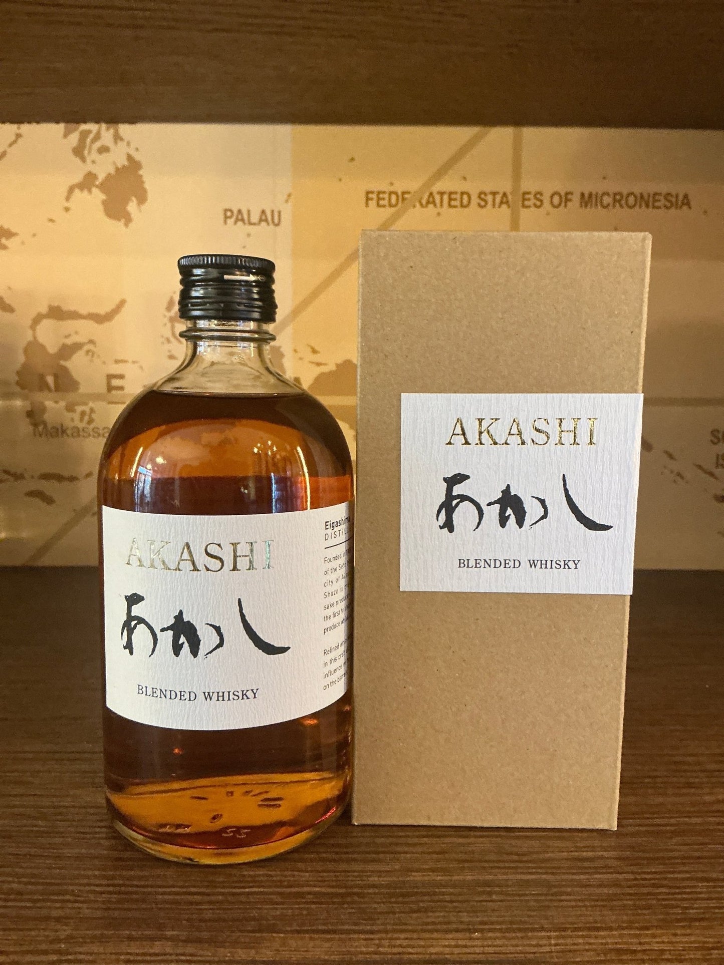 Premium Akashi Blended Whisky bottle with amber liquid, white label featuring Japanese calligraphy, alongside minimalist tan .
