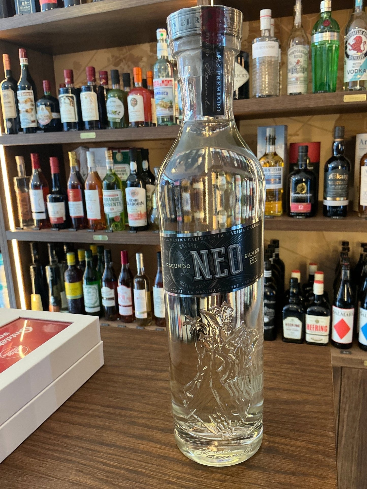 Tall clear glass bottle of Bacardi Facundo Neo premium Puerto Rican white rum with black label, embossed design, and black.