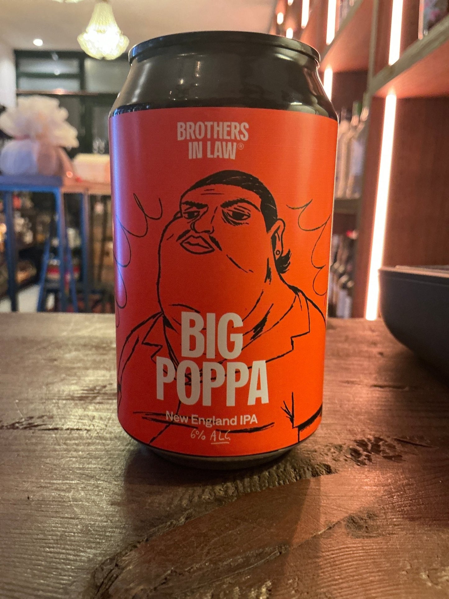 Bright orange can of Big Poppa NEIPA craft beer by Brothers by Law, featuring bold black and white illustration and text,.