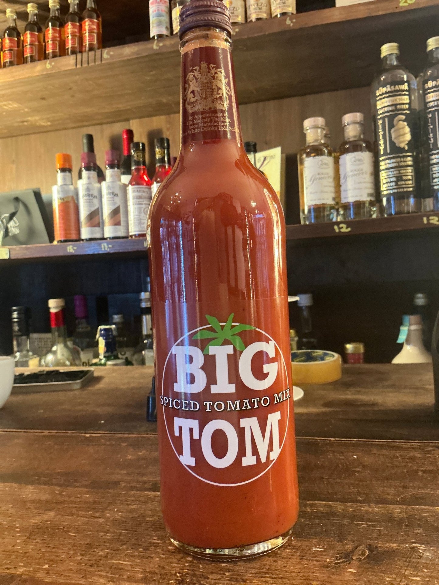 Tall glass bottle of Big Tom Spiced tomato juice with botanical spiced flavor, ideal for premium gin, whisky, rum, bourbon,.