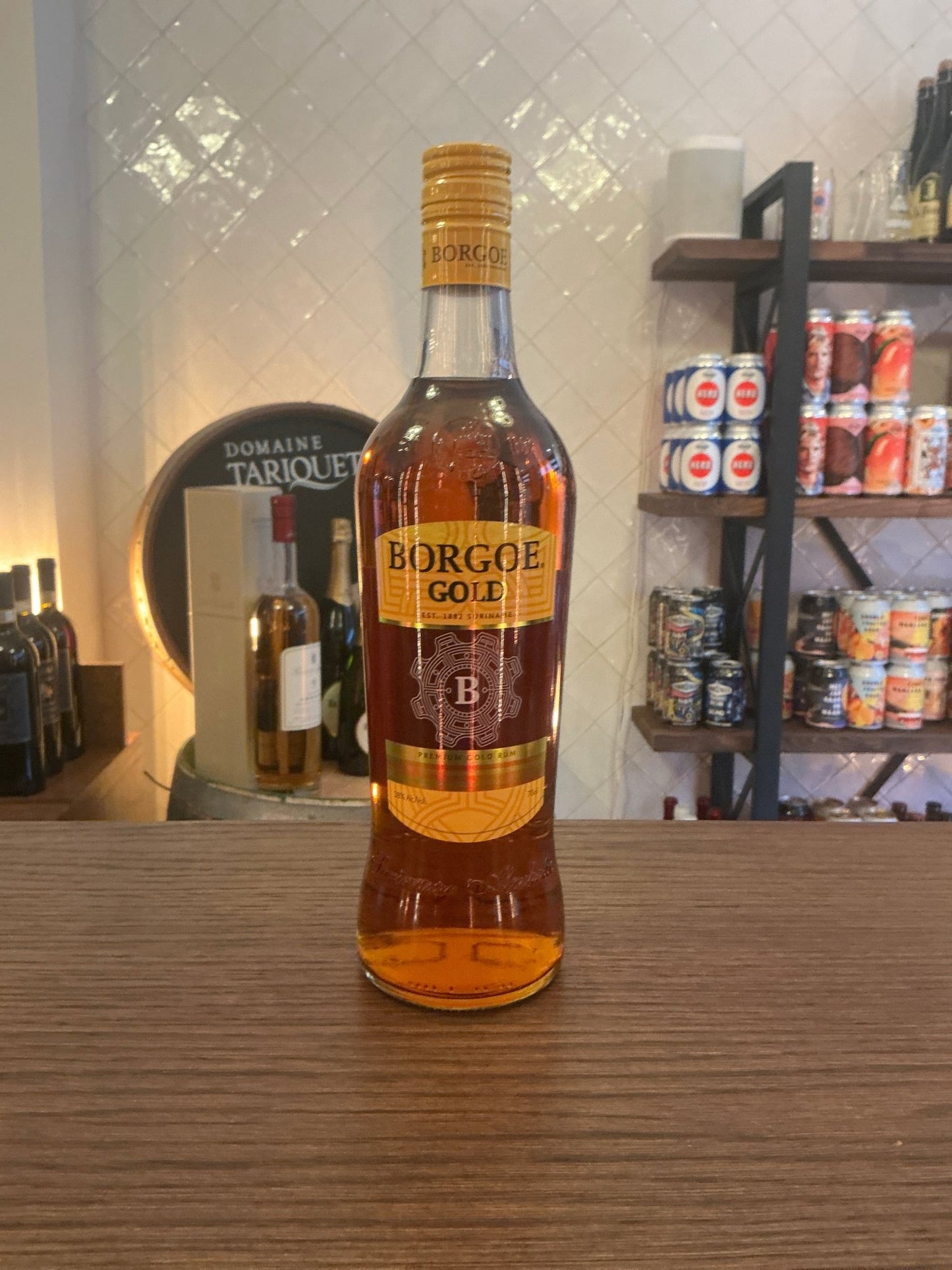 Borgoe Gold Rum bottle with amber liquid, premium aged small batch artisan Dutch spirit, distinctive label on wooden surface.