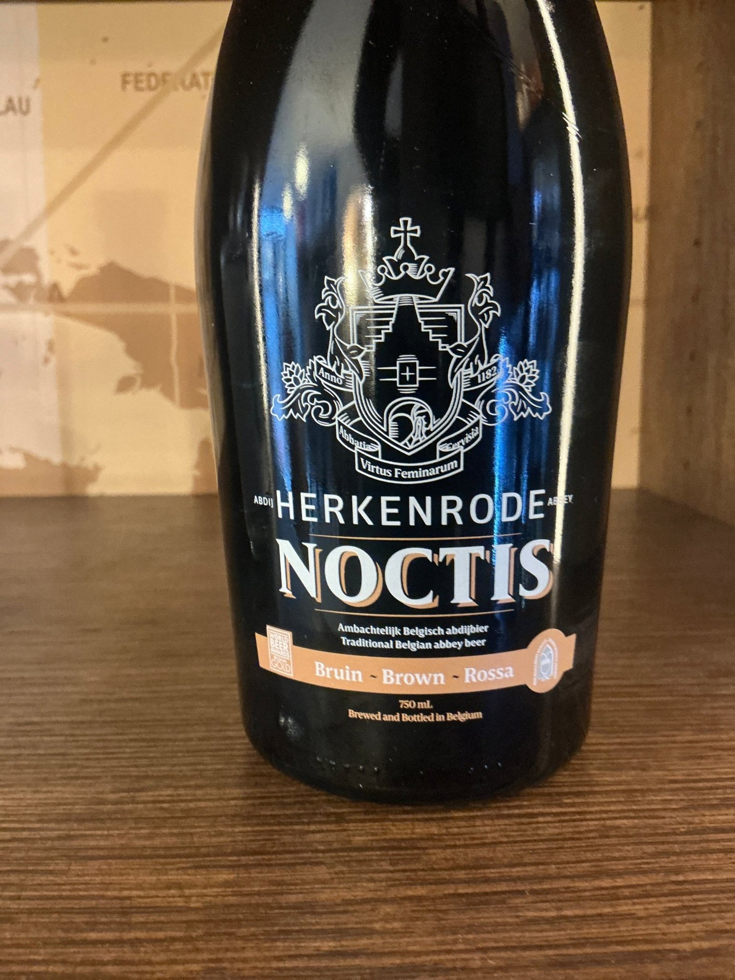 Black bottle of Brouwerij Cornelisen Herkenrode Noctis Belgian Dubbel with white heraldic crest and gold-accented label, a.