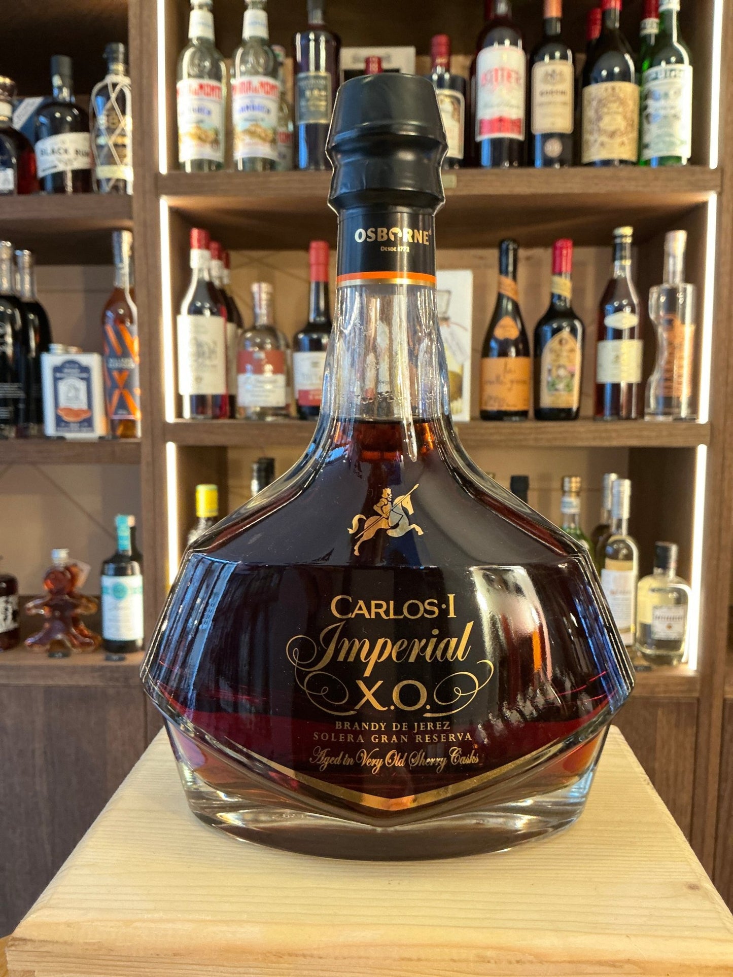 Carlos Imperial X.O. premium aged Spanish brandy in a distinctive faceted glass bottle with black and gold label, rich amber .