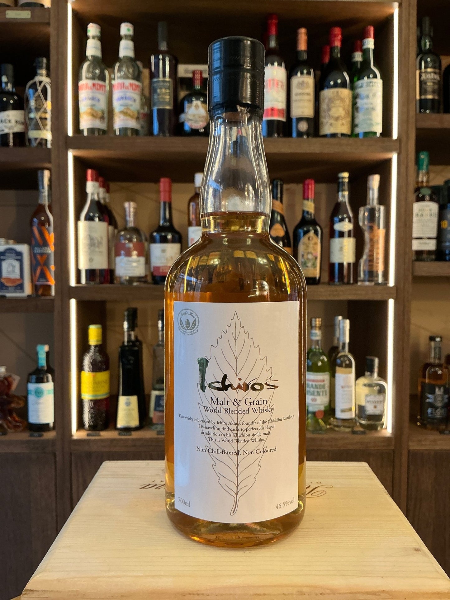 Chichibu Ichiro’s Malt & Grain blended Japanese whisky bottle with clear glass, beige label featuring leaf design, black.