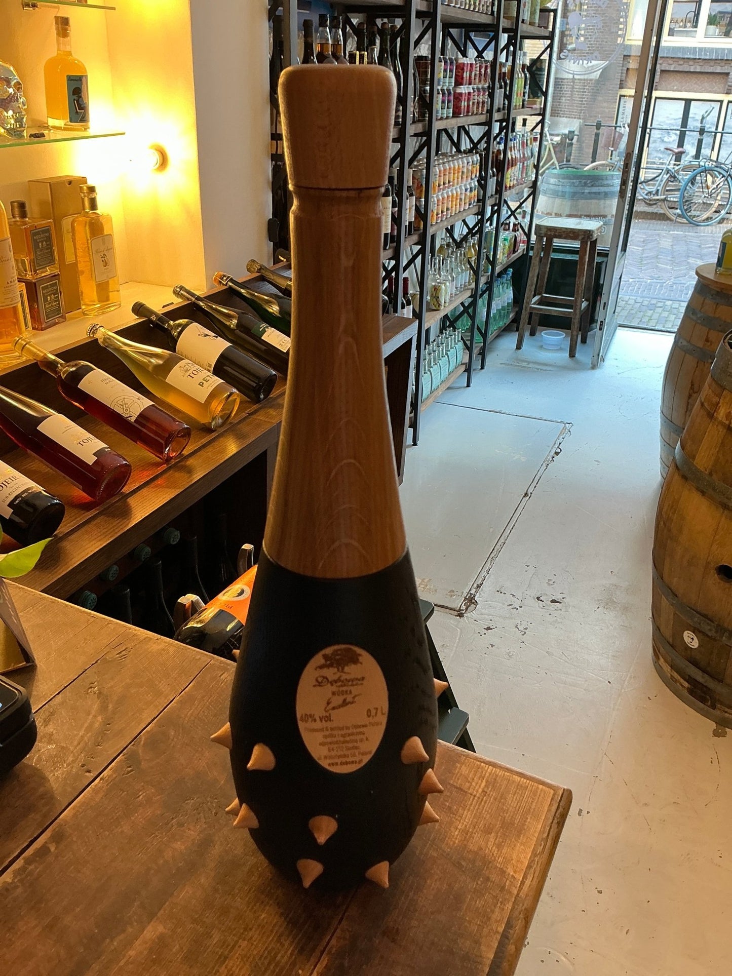 Debowa Oak Vodka Knots premium artisan vodka bottle with distinctive spiked black ceramic casing and tall cork stopper,.