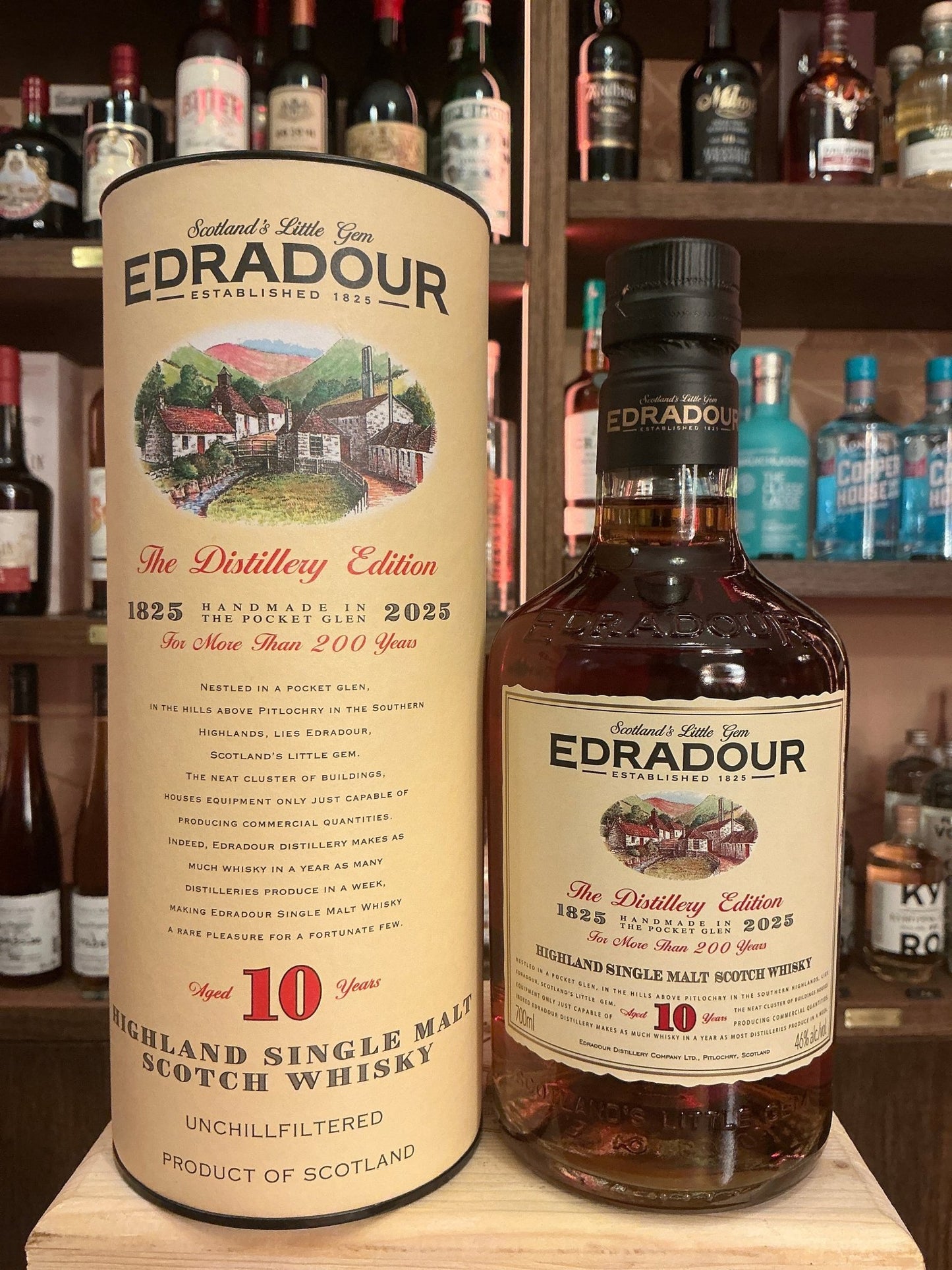 Edradour 10 Year Old Dark Sherry Cask single malt whisky bottle with beige label and red accents on wooden shelf surrounded.