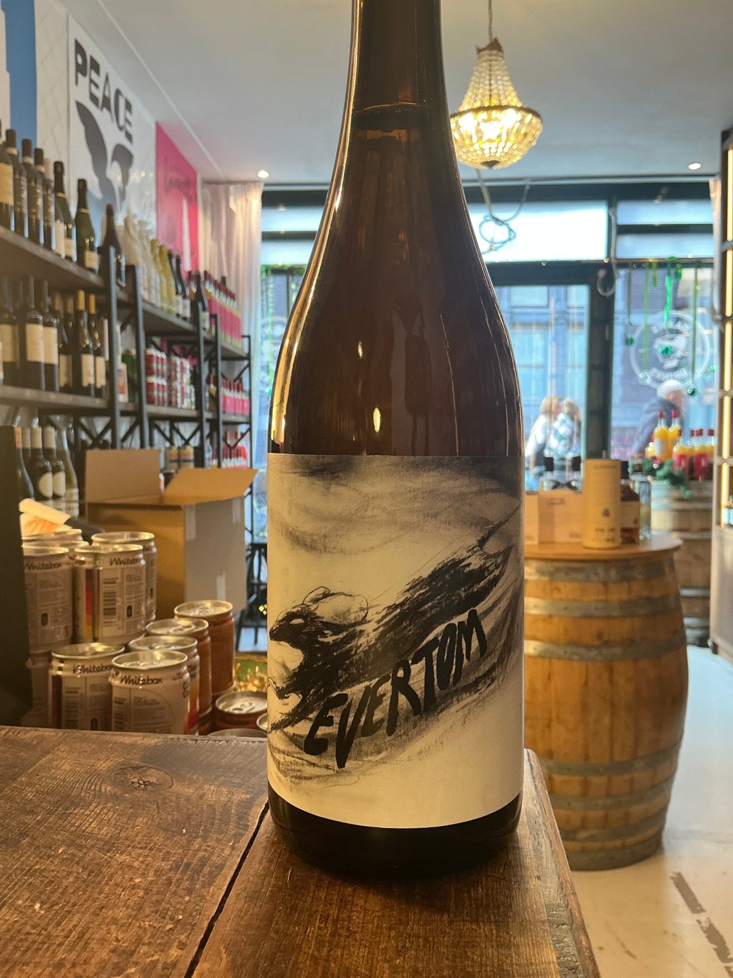 EverTom premium artisan cider bottle with minimalist black-and-white label featuring botanical design, displayed in rustic.