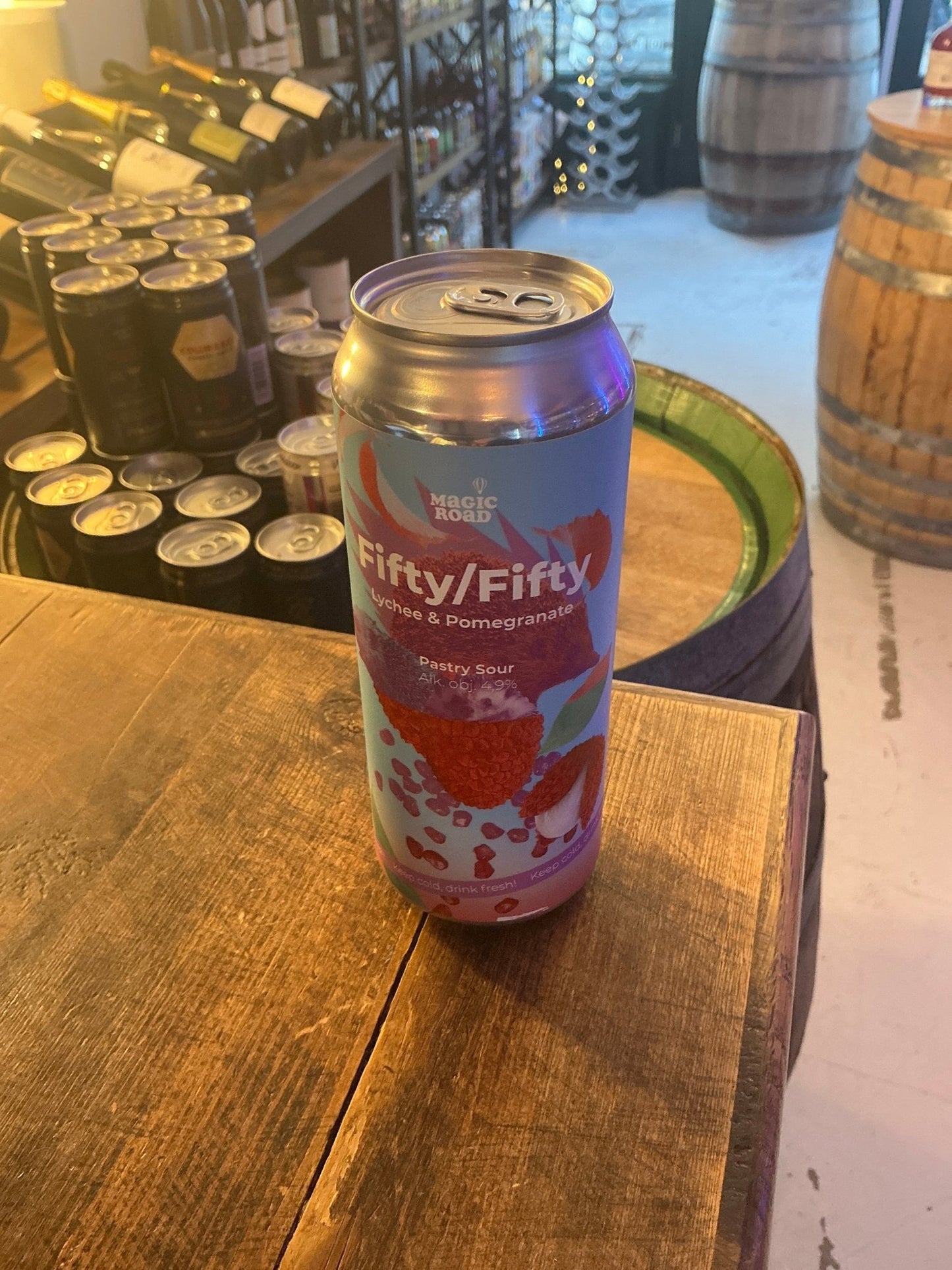 Premium craft Dutch Fifty/Fifty Lychee & Pomegranate fruit beer can with vibrant red and light blue label, limited edition.