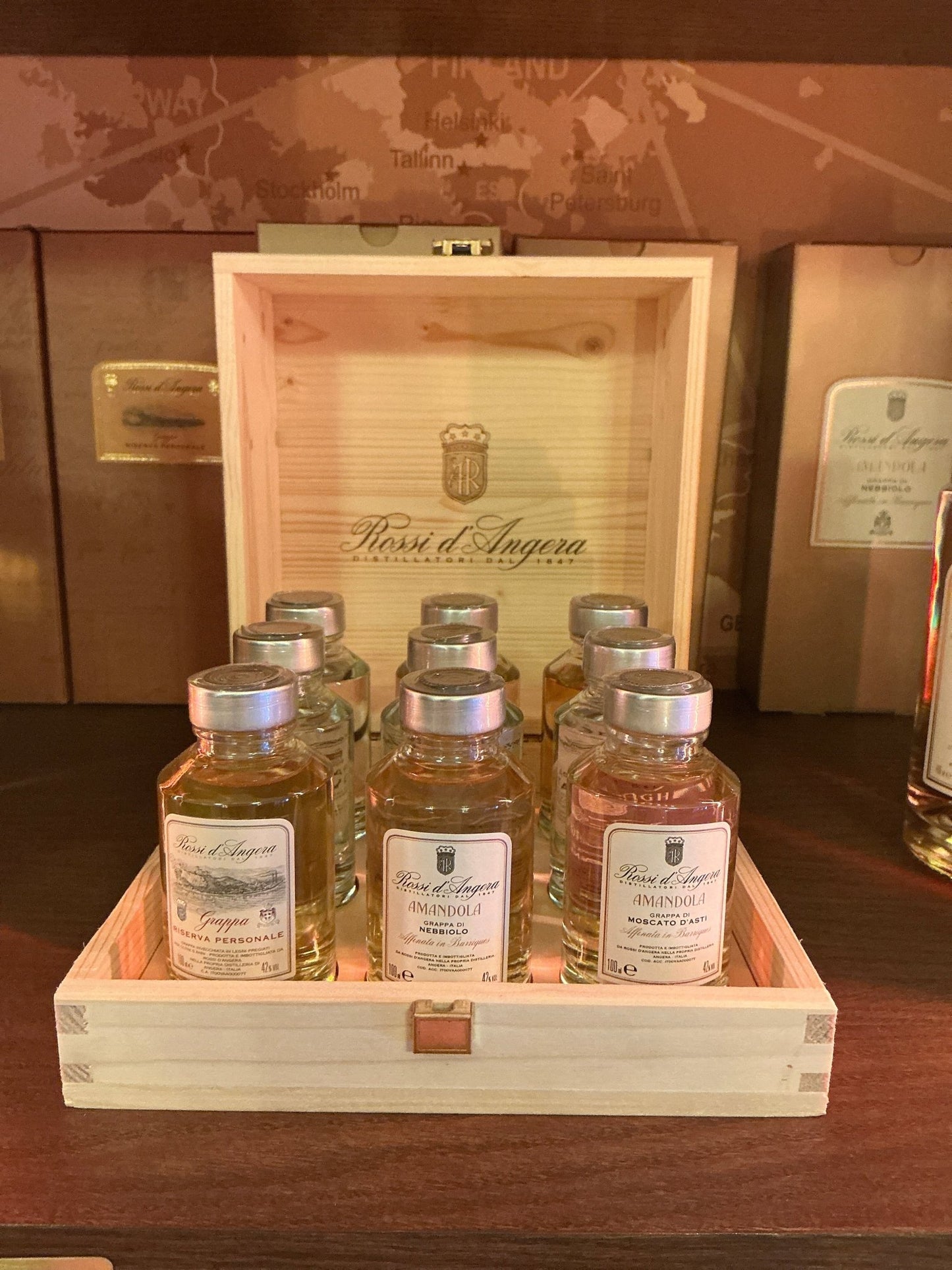 Grappa gift box with six small-batch artisan bottles, premium aged pomace brandy by Rossi D'Angera in clear glass bottles.