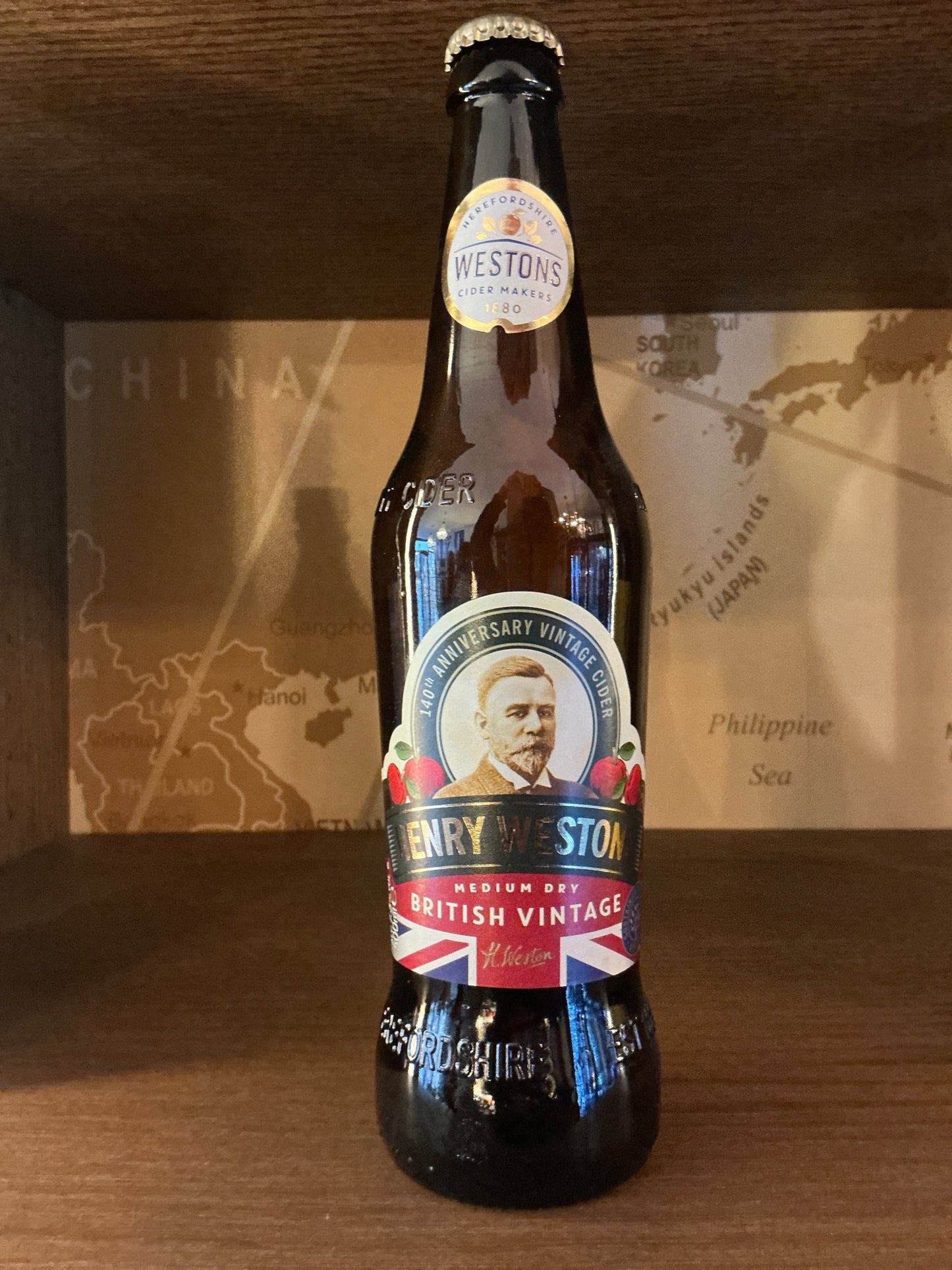 Henry Westons Medium Dry Vintage Cider bottle with vintage-style label featuring portrait, amber glass, premium artisan.