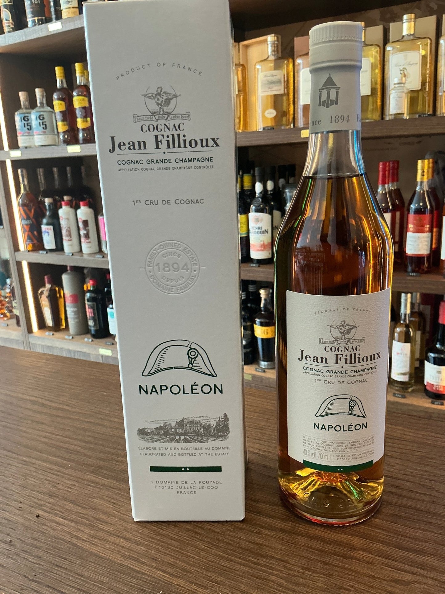 Jean Fillioux Napoleon Cognac bottle with gold amber liquid alongside white box, premium aged brandy, artisan distilled.