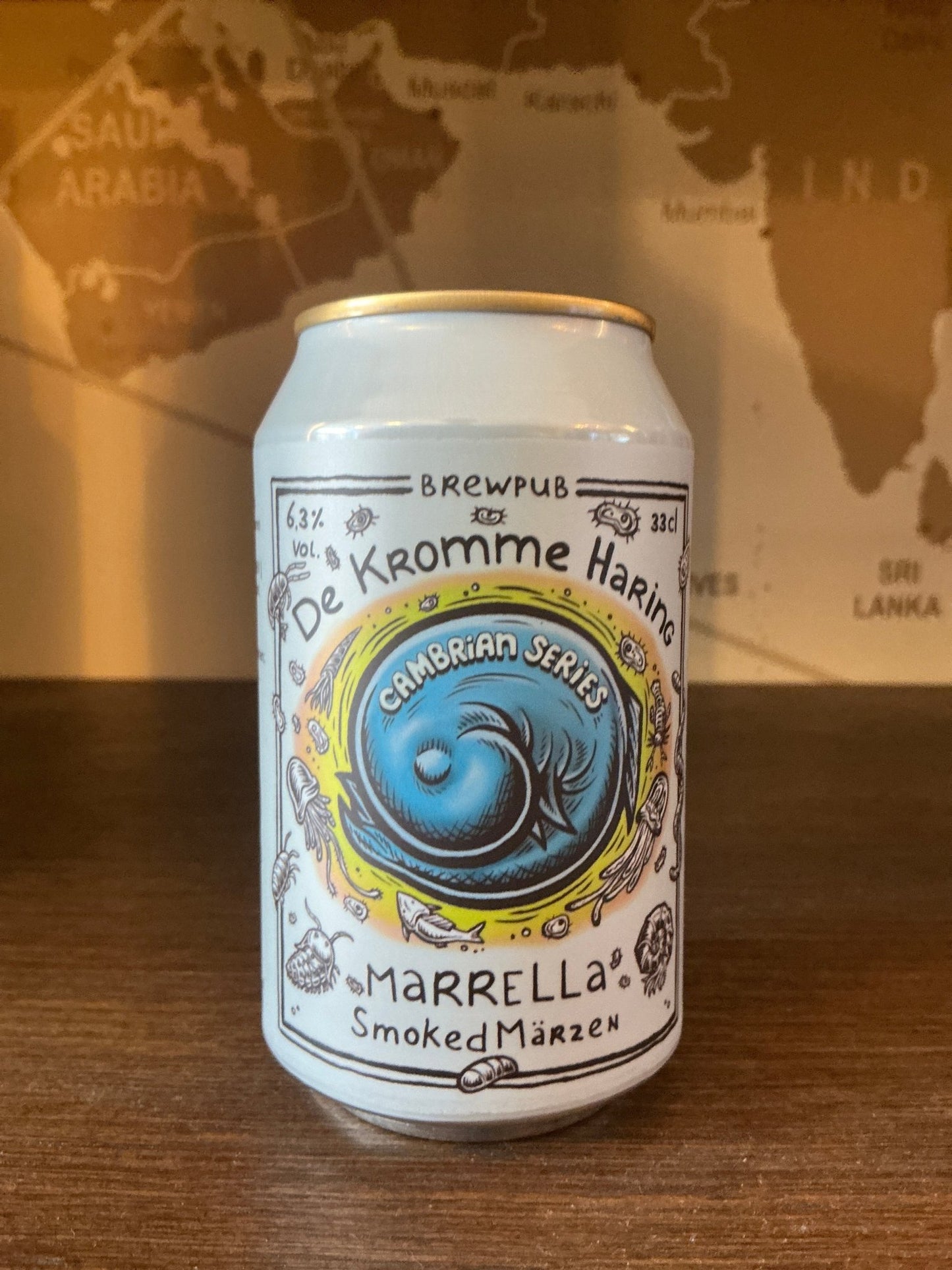 White aluminum can with intricate black and blue line art; central blue circular label with the words Cambrian Series.
