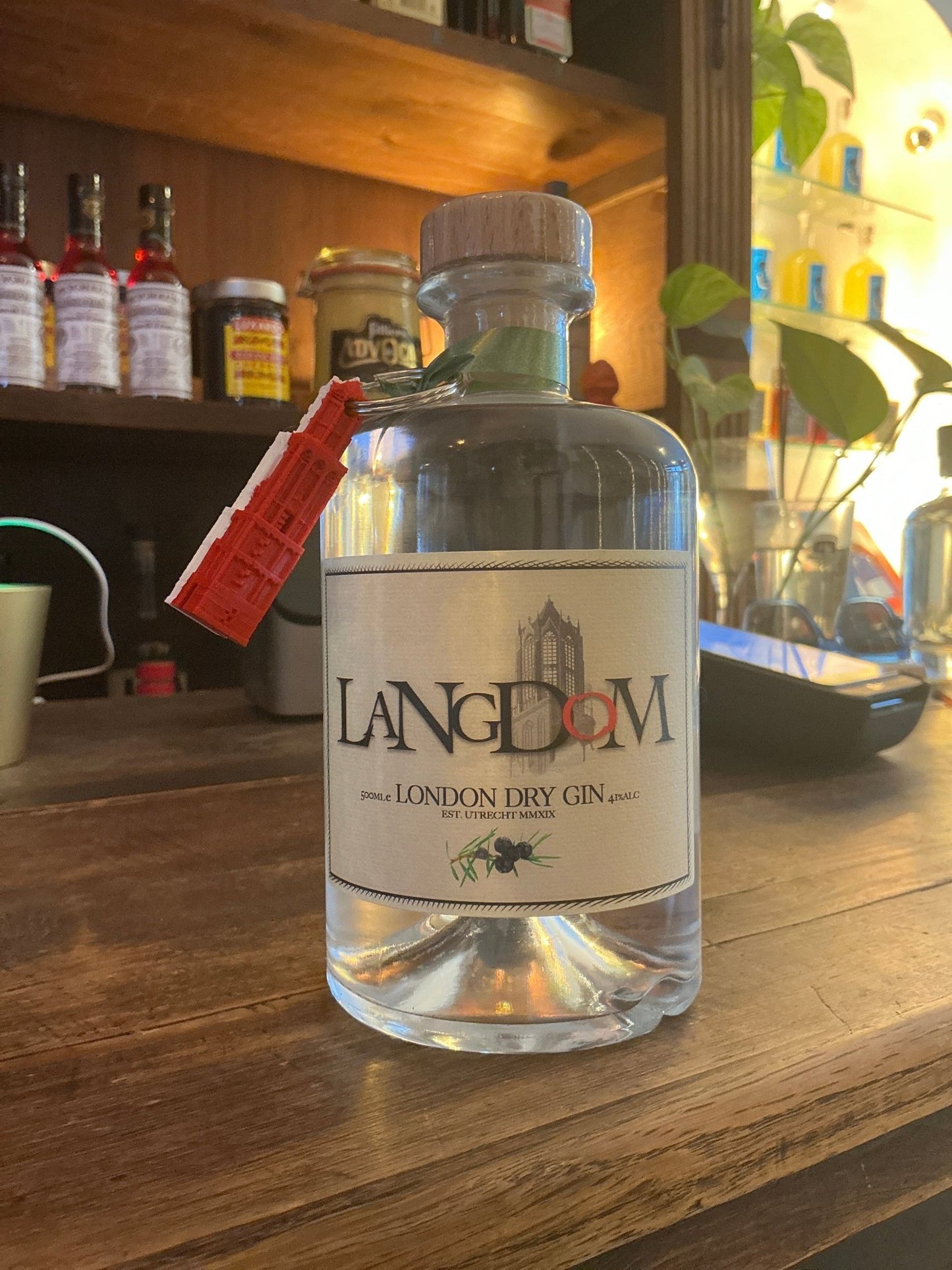LangDom London Dry Gin clear glass bottle with white label, black and red text, botanical and artisan Dutch small batch.