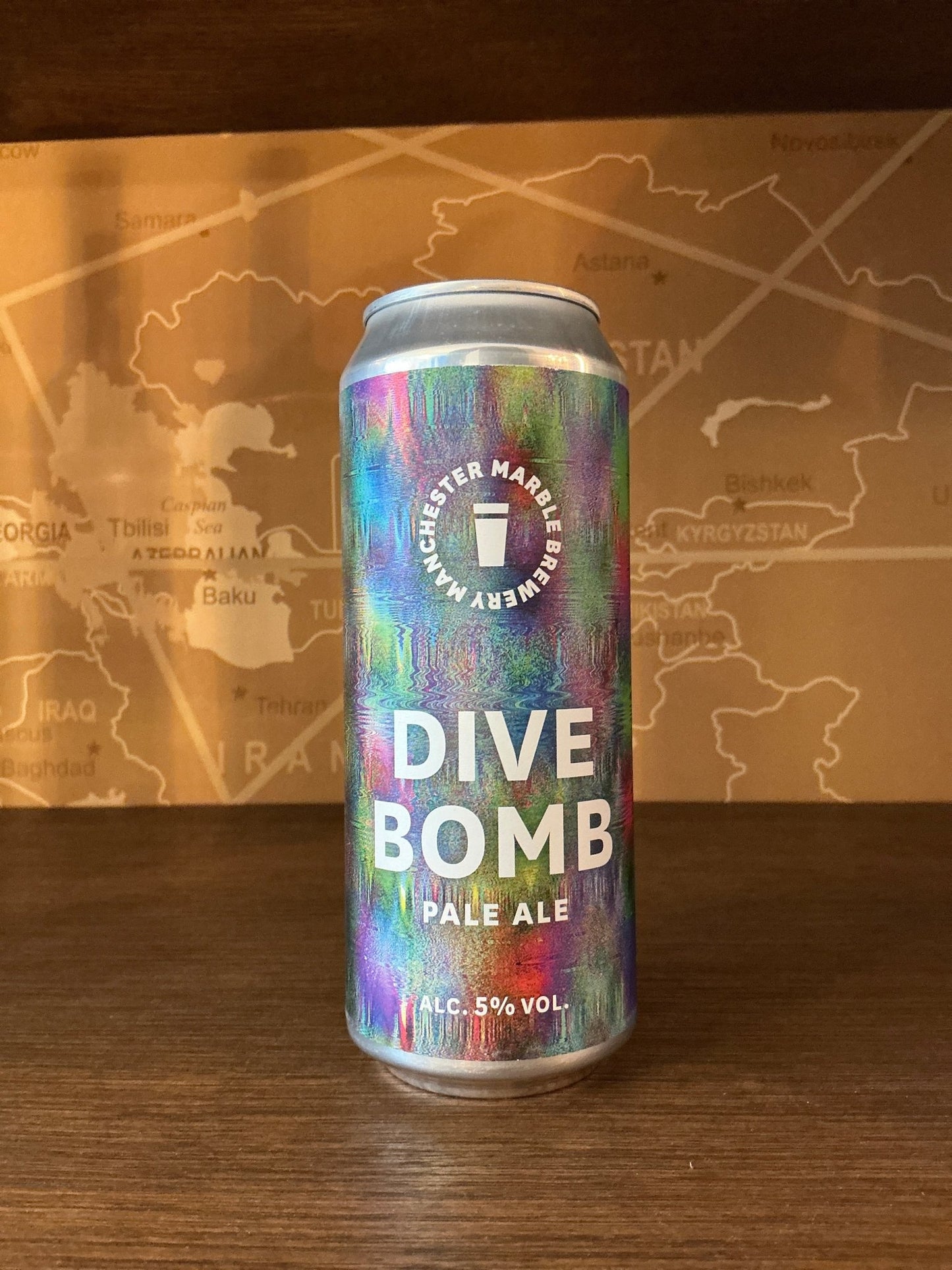Tall can of Manchester Marble Brewery Dive Bomb Pale Ale with vibrant multicolor abstract design, 5% ABV, highlighting.