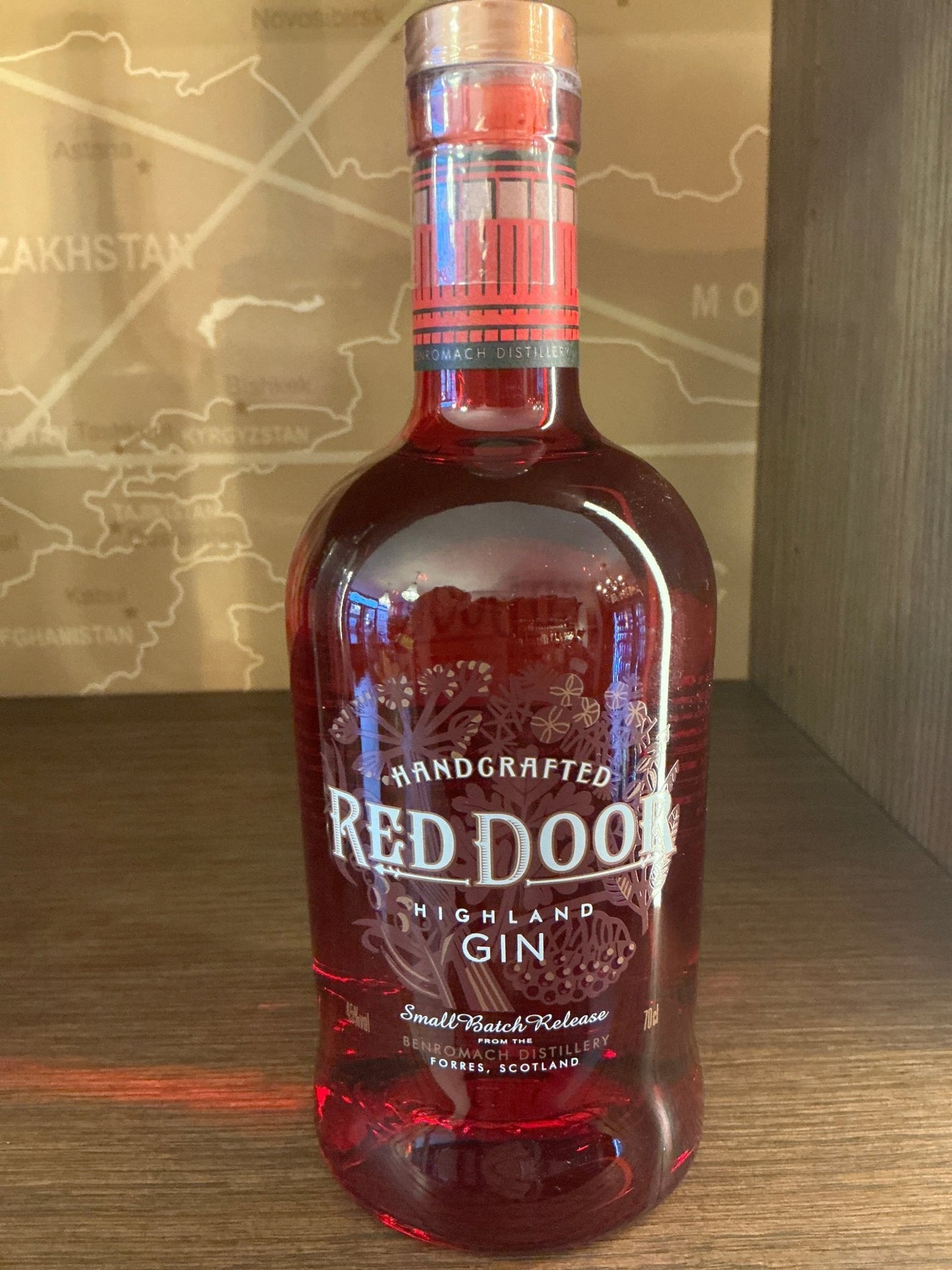 Red Door Highland London Dry Gin in a deep red artisanal glass bottle with bold white and silver lettering, premium craft.