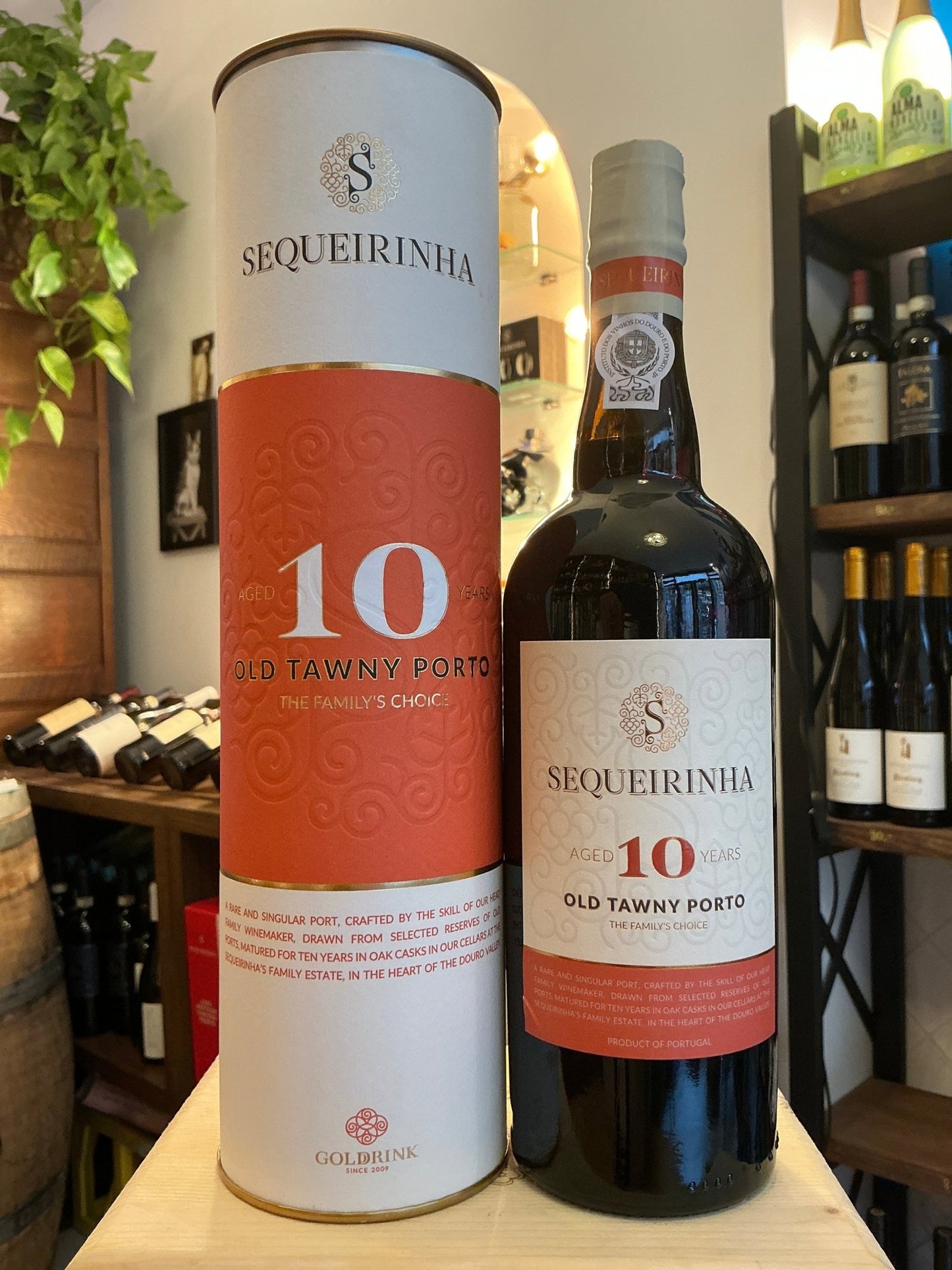 Sequeirinha 10-Year-Old Tawny Port bottle with white and orange label, paired with matching cylindrical packaging, premium.