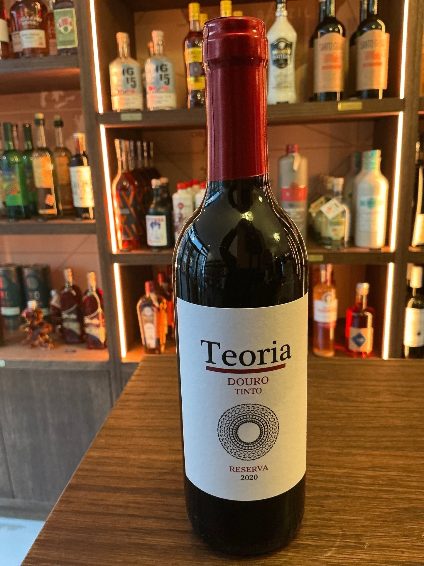 Teoria Reserva 2020 37.5cl Portuguese red wine bottle with white label and red foil cap on wooden table, artisan spirit.