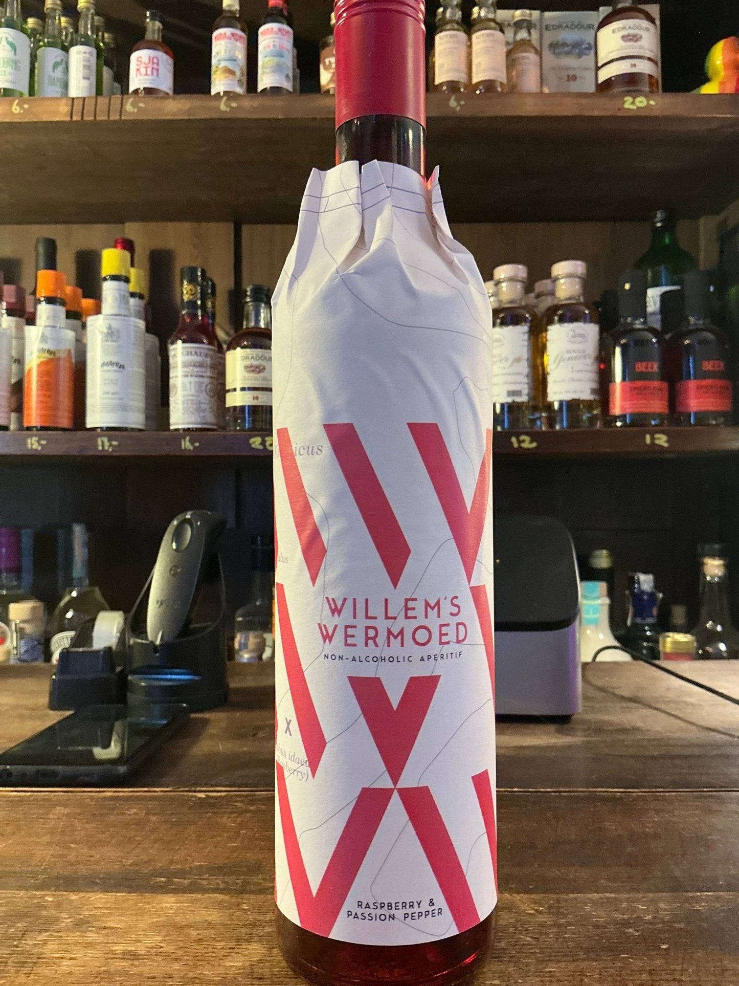 Tall white bottle with bold red geometric "W" design, labeled Willem's Wermoed Raspberry & Passion Pepper artisan.