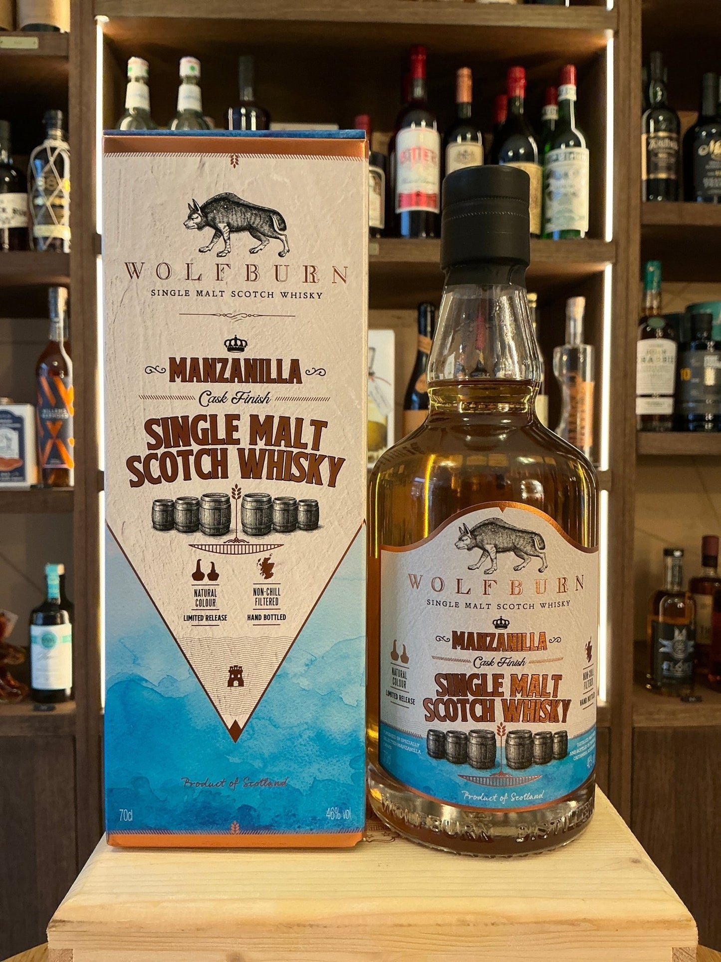 Wolfburn Marzabilia single malt Scotch whisky bottle with blue and white boxed packaging on wooden shelf with various.