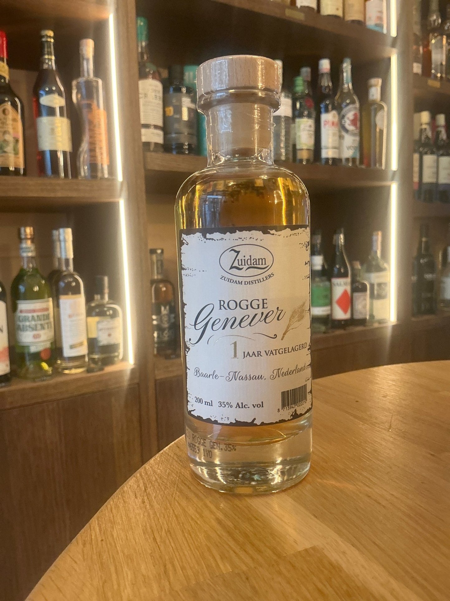 Zuidam Rogge Genever 1 Year aged Dutch botanical rye spirit in clear glass bottle with wooden cap on wooden counter, premium .