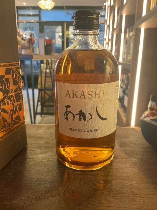 Clear glass bottle of Akashi Blended Whisky with amber liquid, black cap, and Japanese script label, artisan small batch.