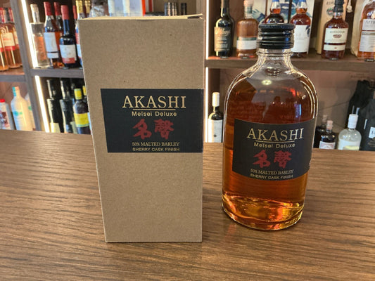 Akashi Meisei Deluxe Sherry Cask Japanese whisky bottle with amber liquid next to premium branded tan box on wooden shelf.