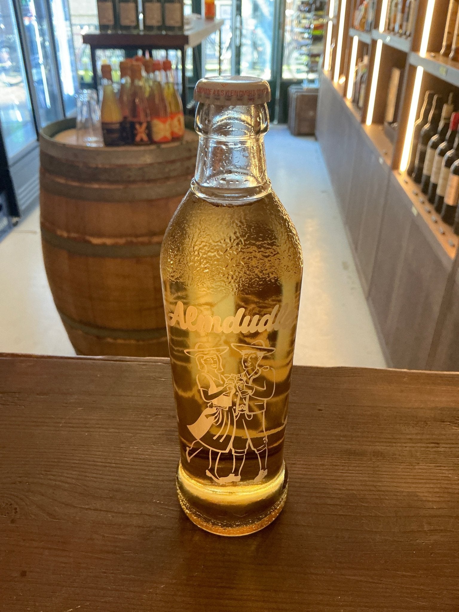 Almdudler Original 350ml Austrian herbal soft drink bottle with golden liquid, artisan botanical lemonade, premium.