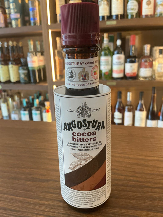 Angostura Cocoa Bitters bottle with maroon cap, white label featuring brown diagonal cocoa design, premium small batch.