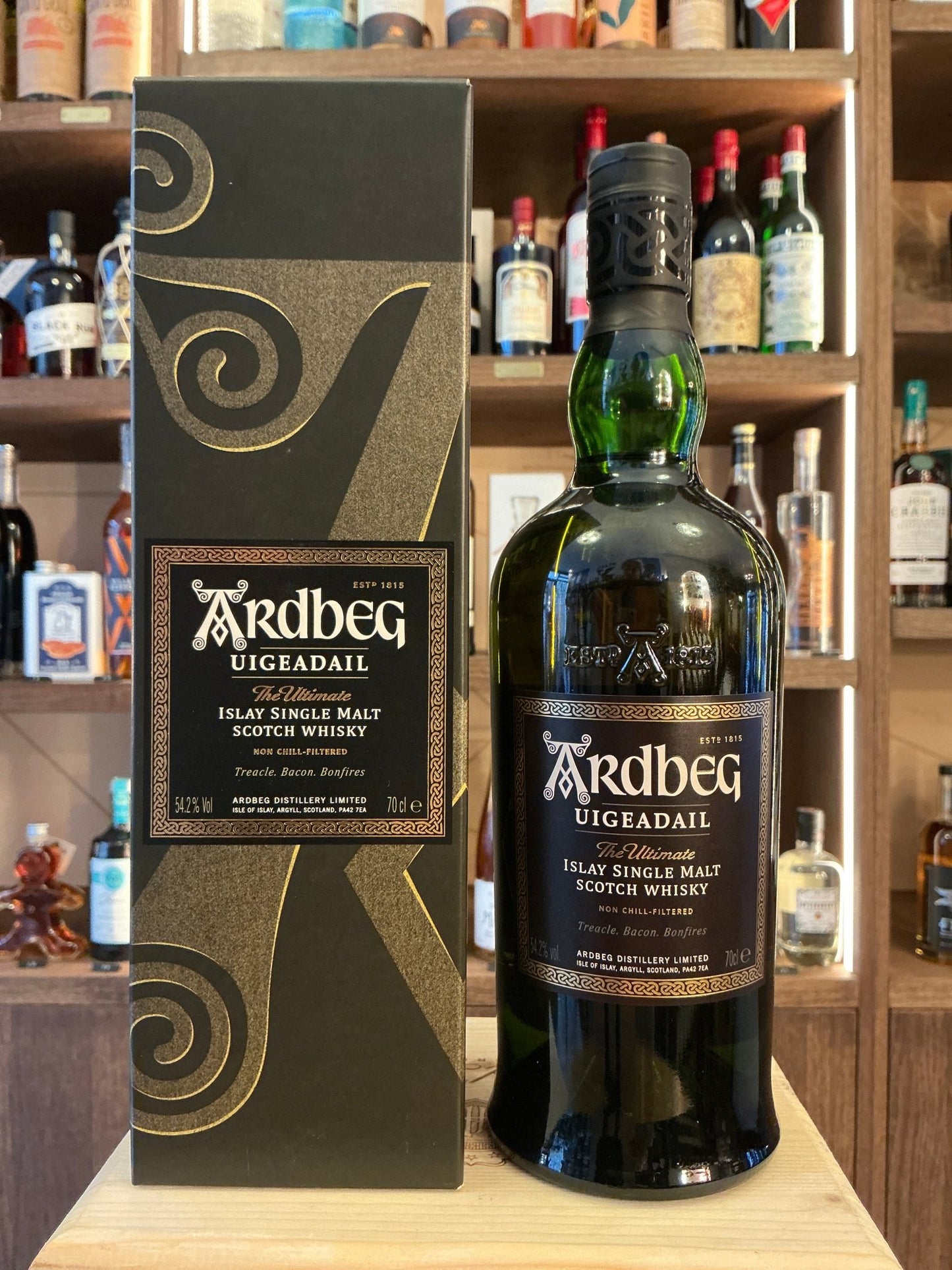 Ardbeg Uigeadail peated single malt whisky bottle with black and gold label next to matching premium dark green and gold box .