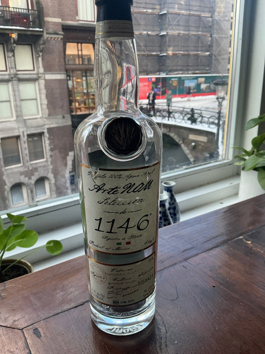 Arte Nom 1146 Añejo tequila in clear glass bottle with vintage-style label, premium small-batch artisan spirit distilled in.