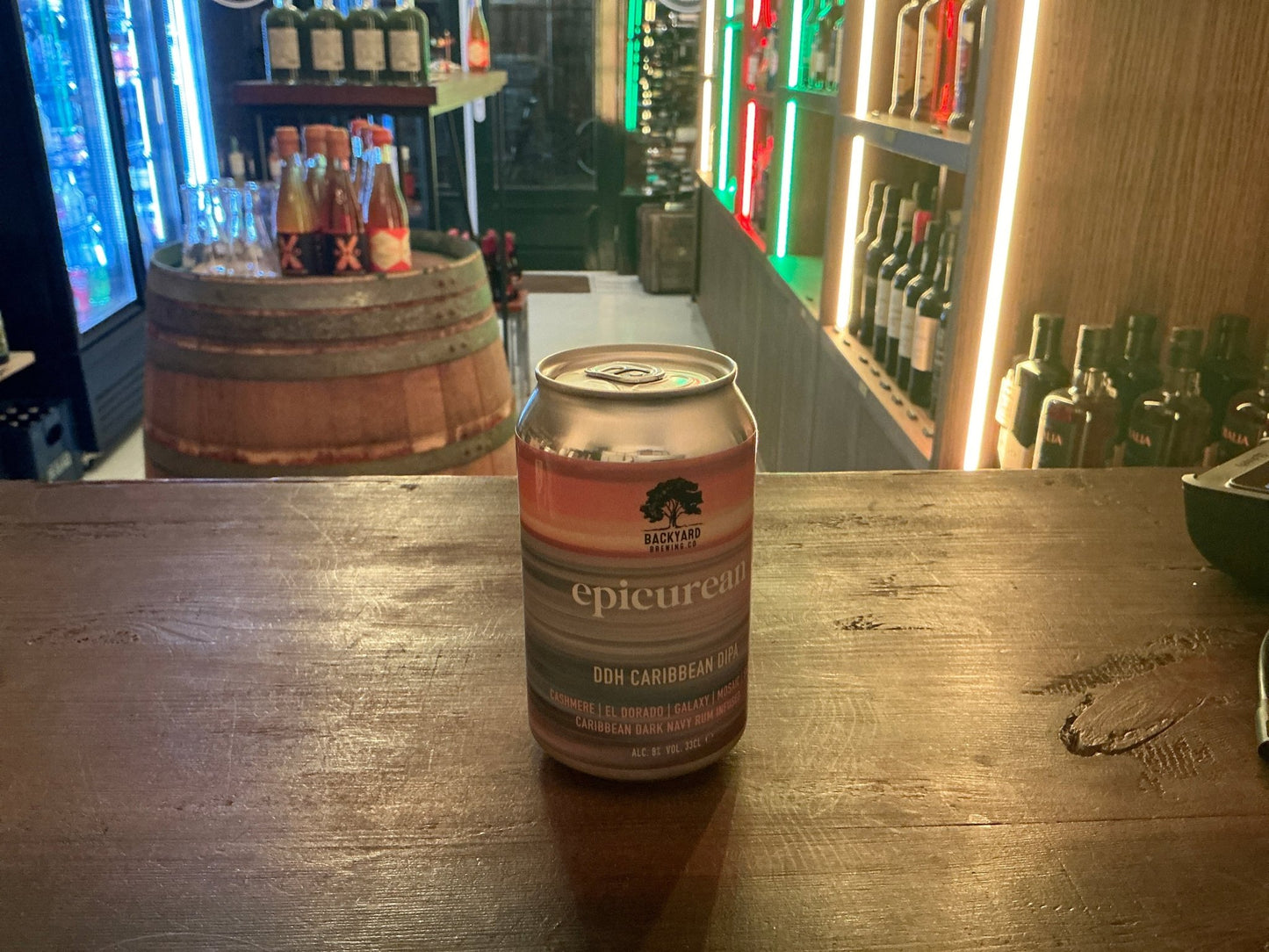 Backyard Brewing Epicurean DIPA craft beer can with botanical and spiced notes on wooden bar with premium spirits shelves in .