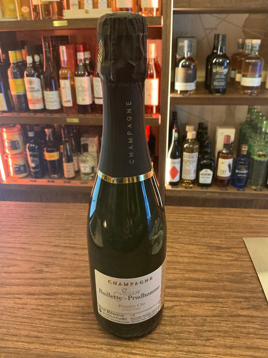 Baillette Prudhomme Champagne 37.5cl bottle with black foil top on wooden bar, premium artisan Dutch specialty spirit.