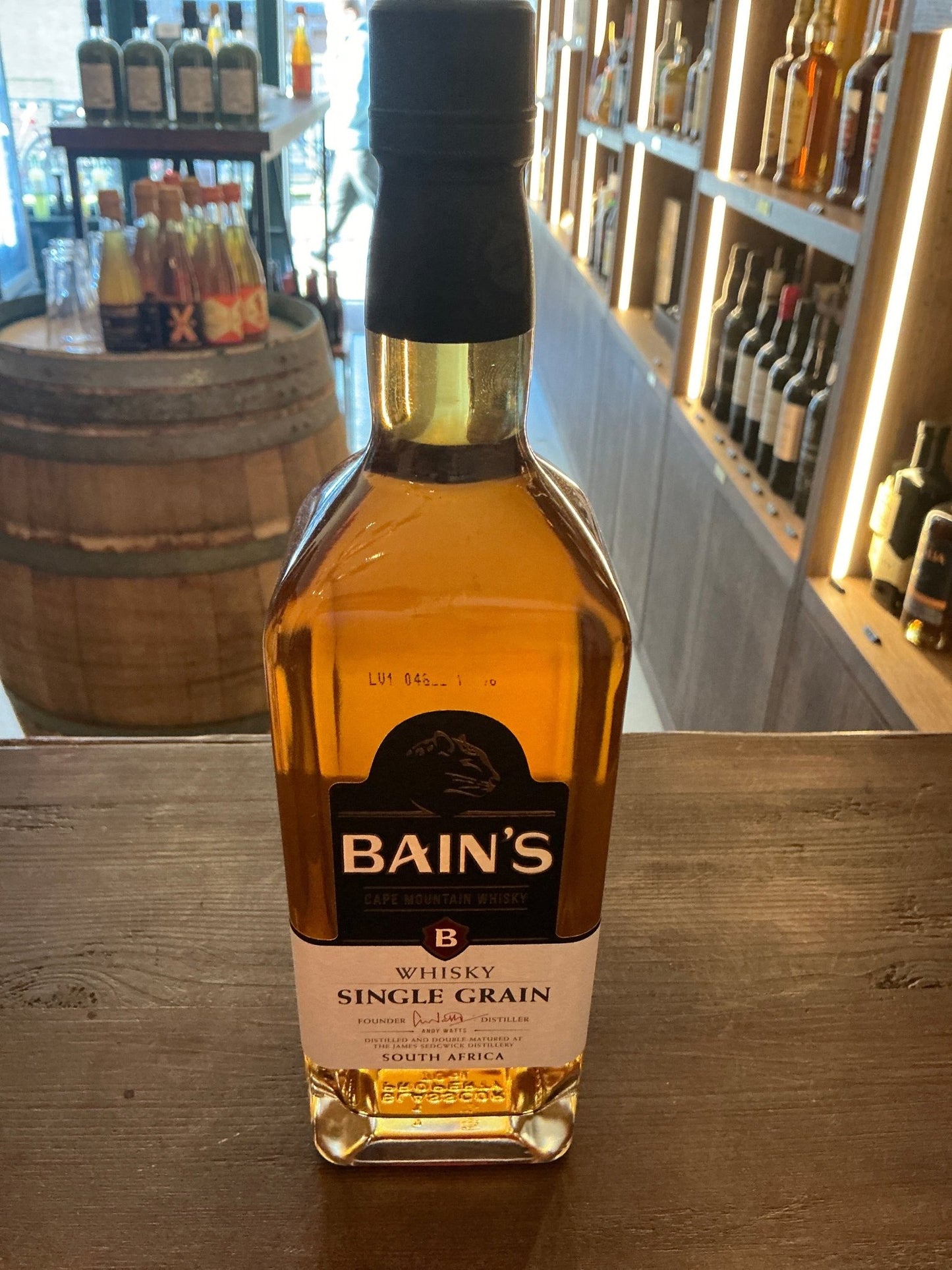 Bain’s Cape Mountain Single Grain Whisky bottle with golden amber liquid, premium small batch artisan spirit, distilled and.