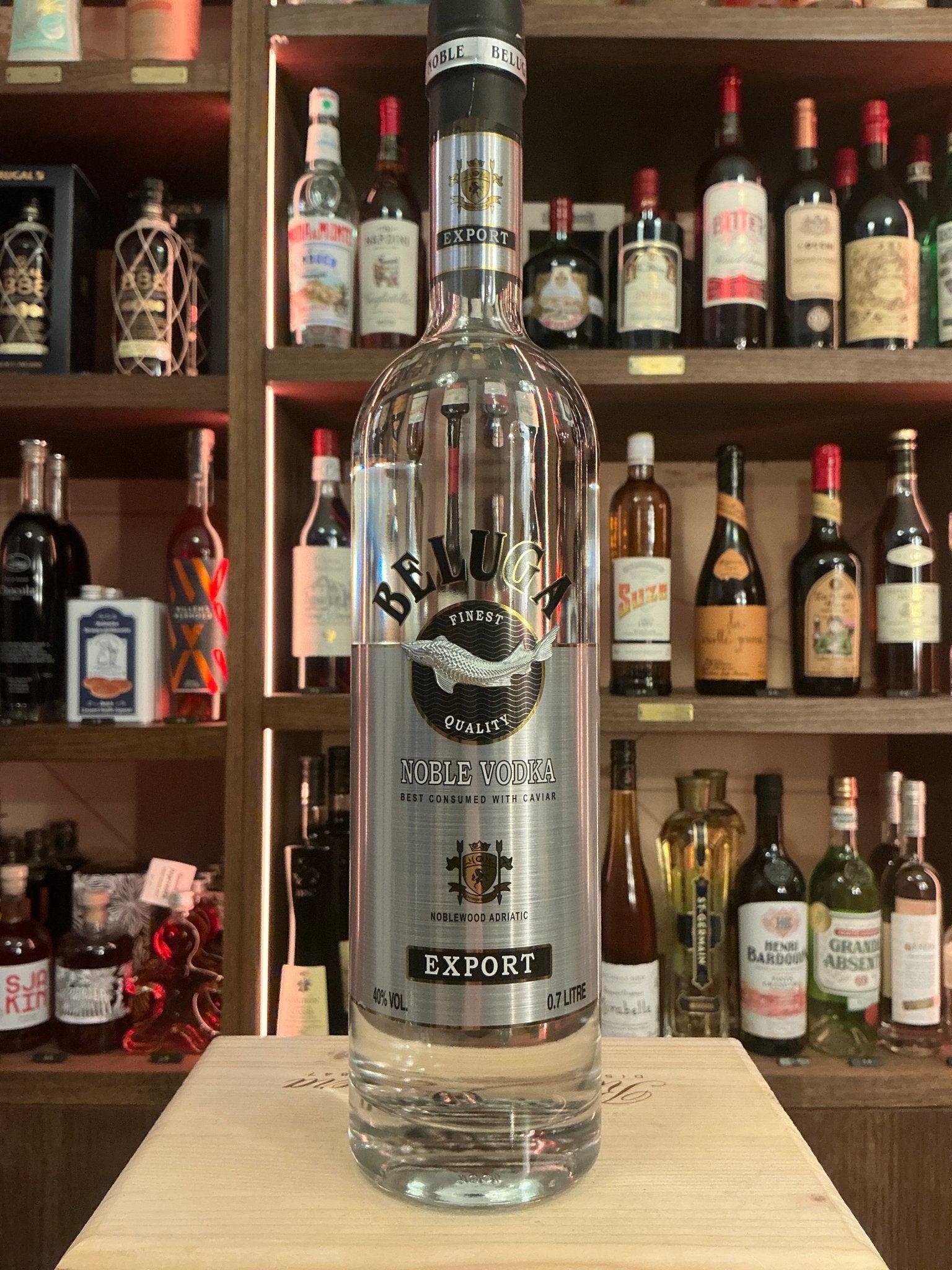 Beluga Vodka clear premium distilled vodka bottle with black and silver label on wooden surface in liquor store.