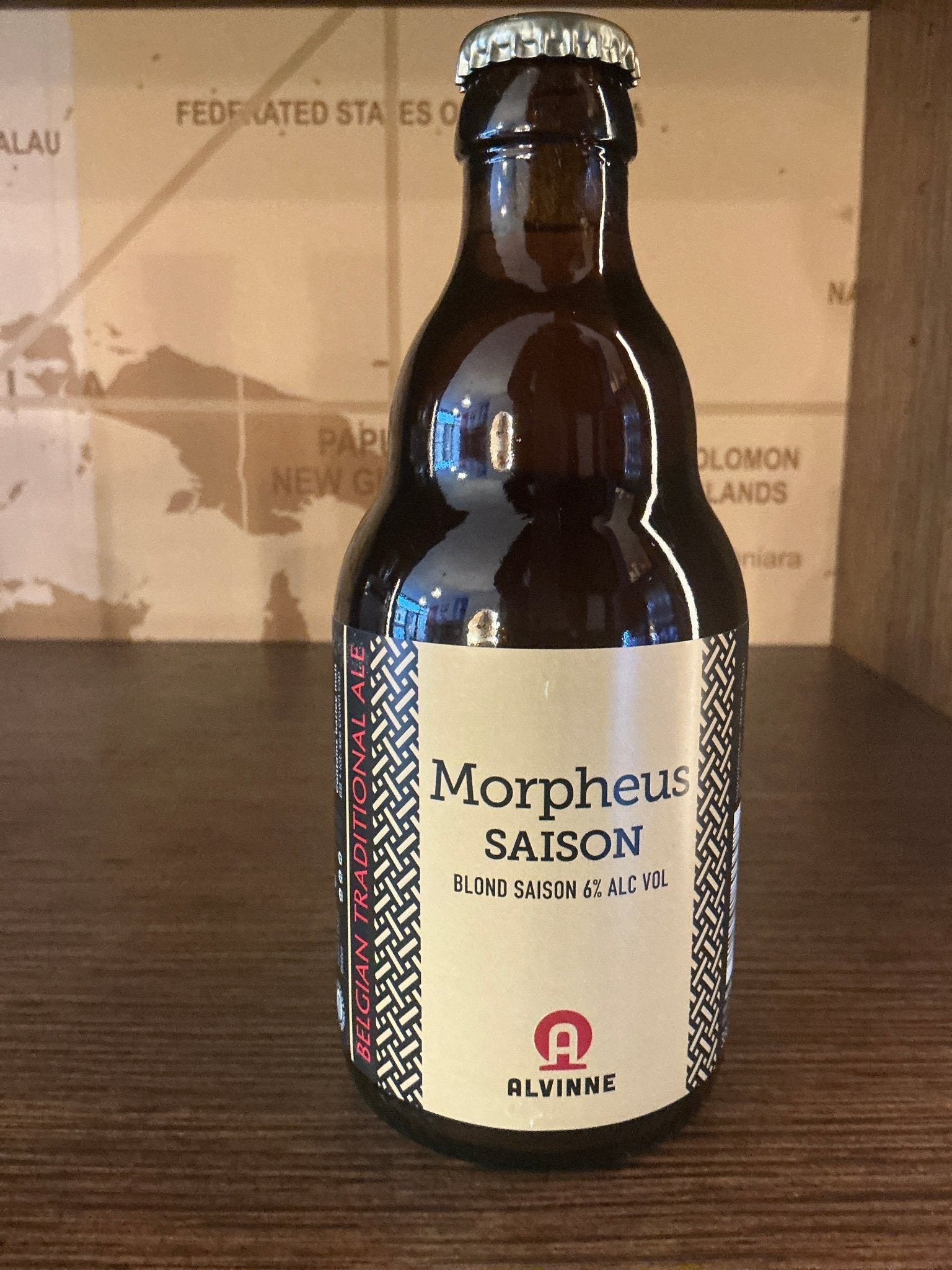 Dark brown glass bottle of Brouwerij Alvinne Morpheus Saison farmhouse ale with a cream label featuring blue and red.