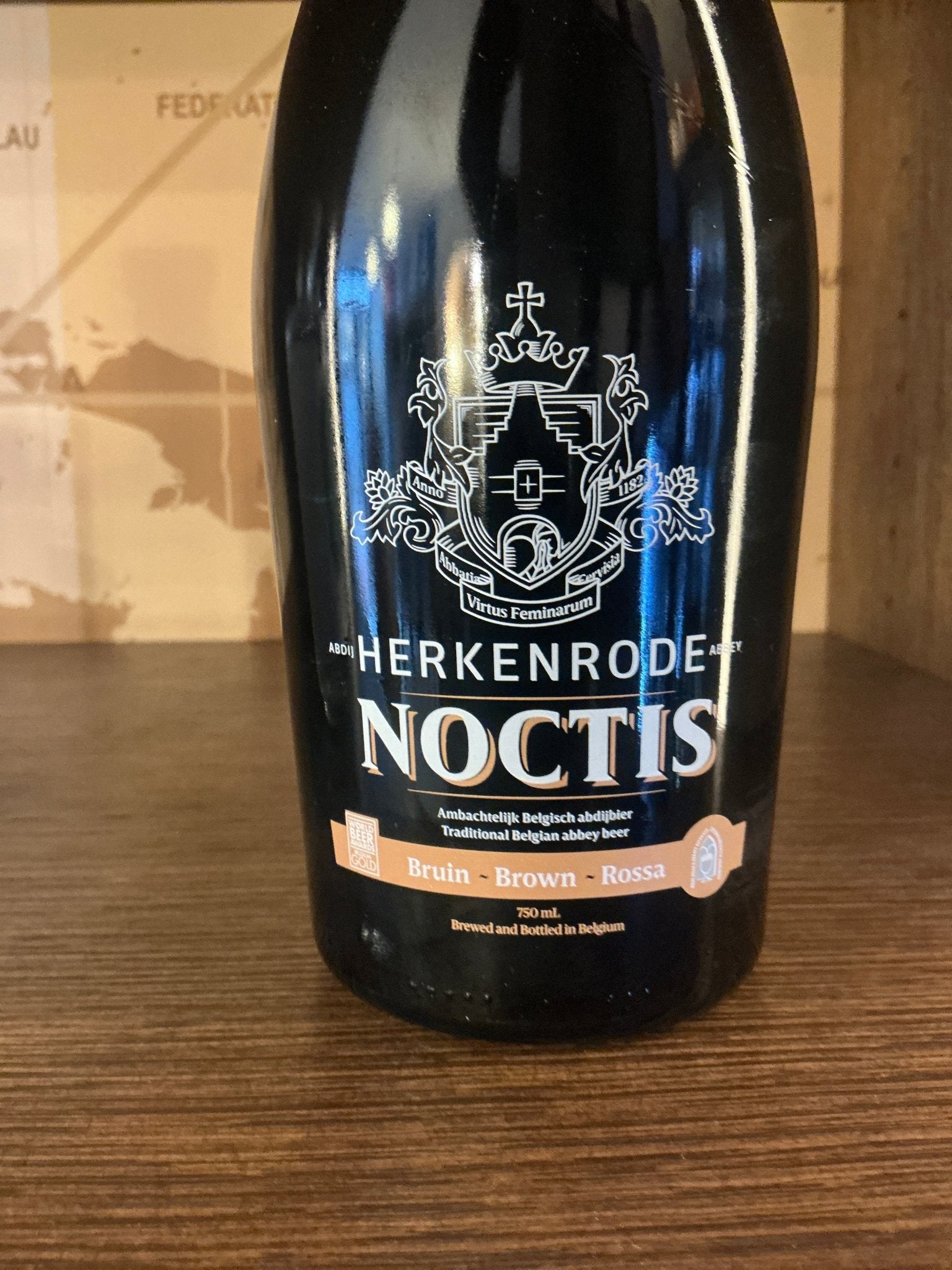 Black bottle of Brouwerij Cornelisen Herkenrode Noctis Belgian Dubbel with white heraldic crest and gold-accented label, a.