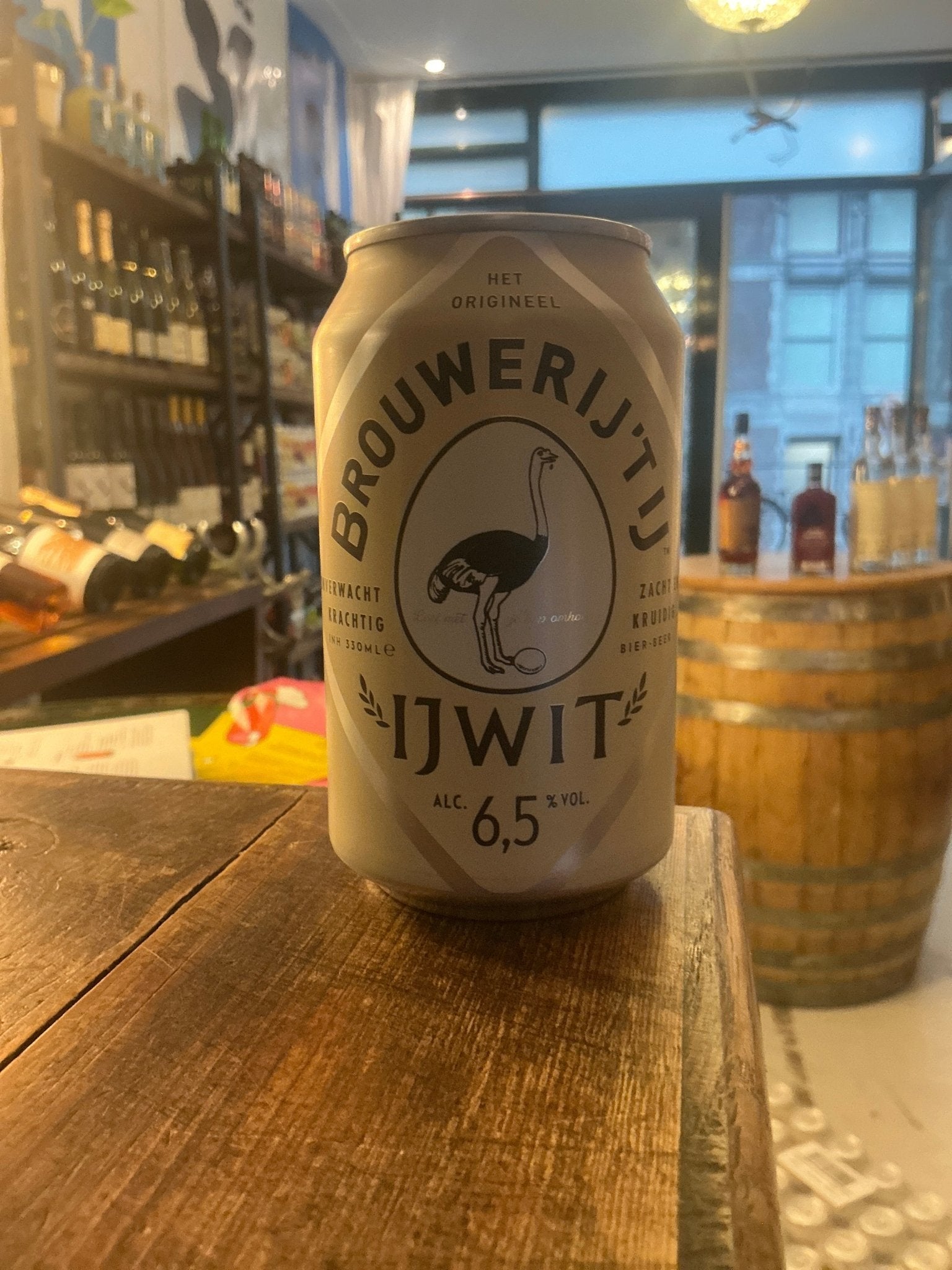 Brouwerij ‘T IJ Ijwit wheat craft beer can with 6.5% ABV, premium Dutch artisan brew on wooden bar table.