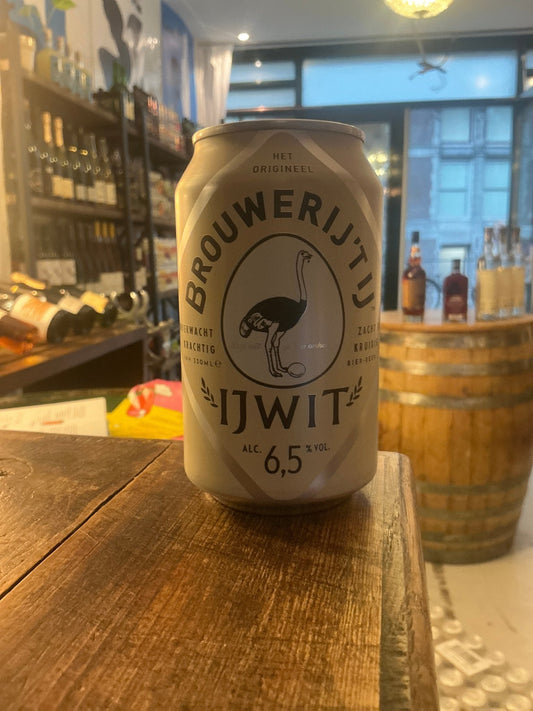 Brouwerij ‘T IJ Ijwit wheat craft beer can with 6.5% ABV, premium Dutch artisan brew on wooden bar table.