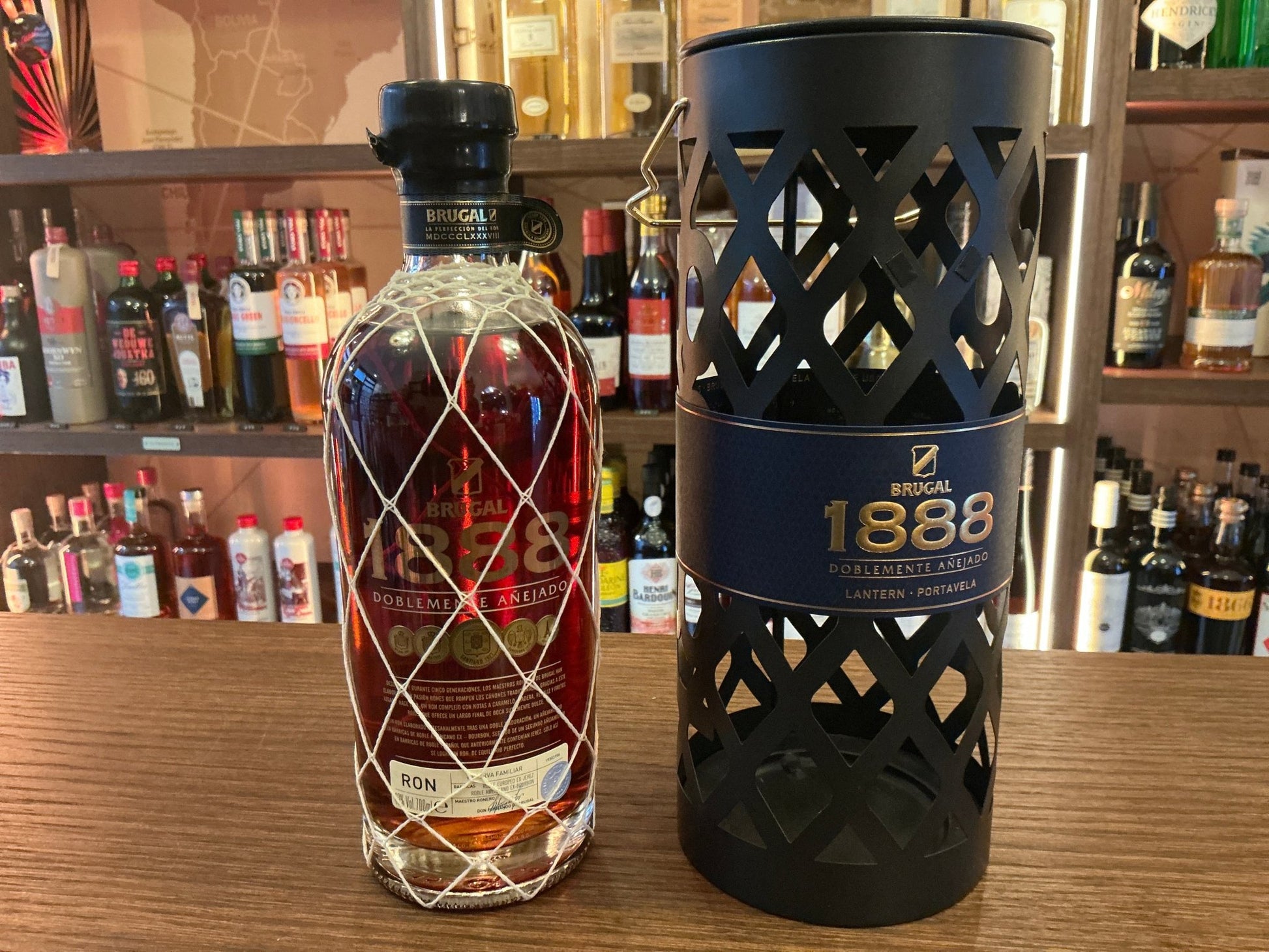 Brugal 1888 aged Dominican rum in a tall glass bottle with black lattice-patterned leather sleeve and matching cylindrical.