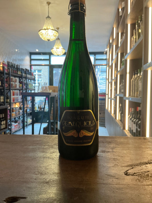 Green glass bottle of Bruis & Ketel Gembruicius sparkling fruit wine with black and gold label on wooden surface in.