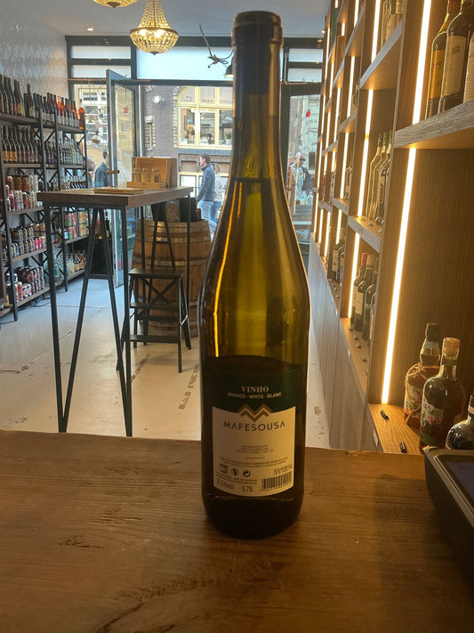 Tall green glass bottle of Casa da Tojeira Mafesousa 2023 Portuguese white wine with detailed label on a wooden counter in a .