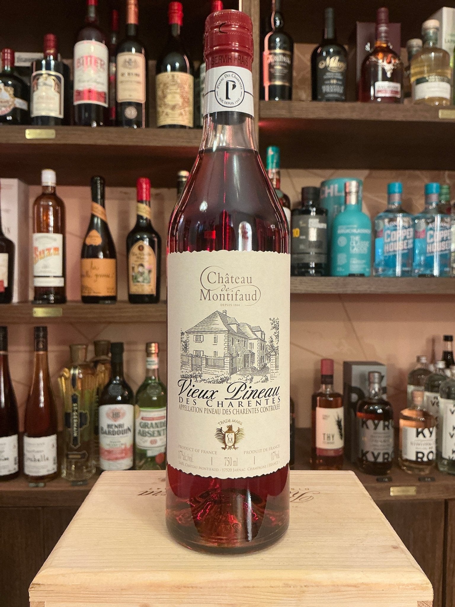 Chateau de Montifaud Vieux Pineau des Charentes Rouge bottle with deep red fortified fruit wine, artisan specialty spirit,.