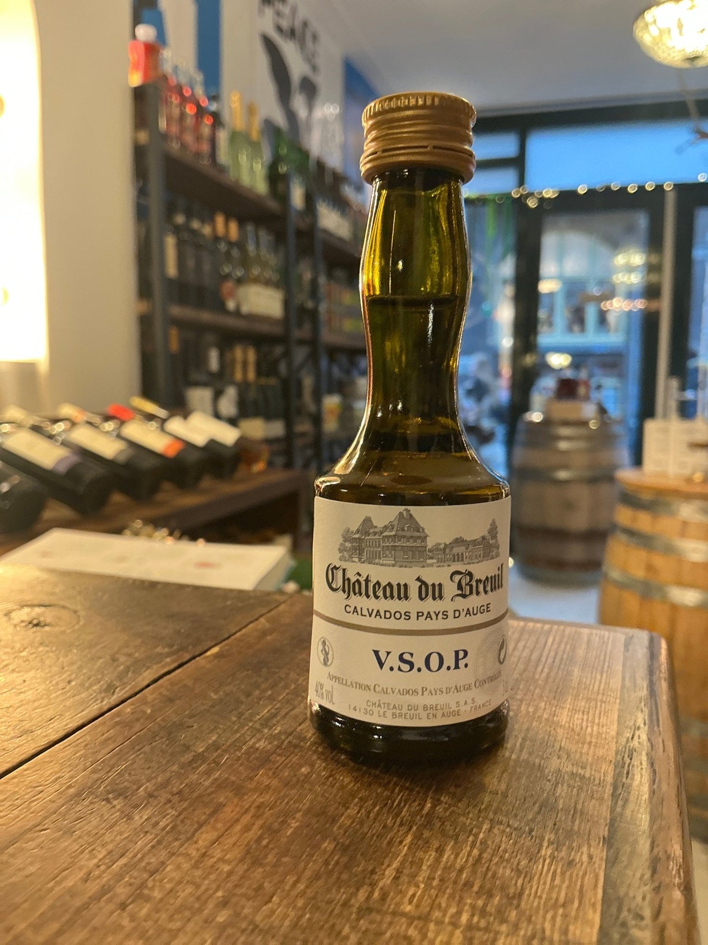 Château du Breuil Calvados VSOP small batch bottle of premium aged brandy with botanical spiced notes on wooden table.