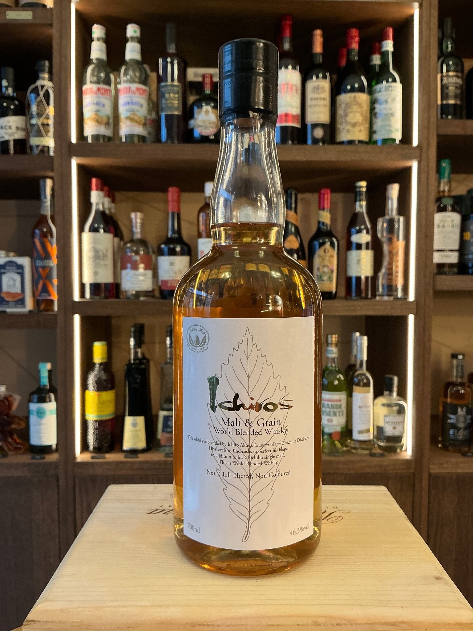 Chichibu Ichiro’s Malt & Grain blended Japanese whisky bottle with clear glass, beige label featuring leaf design, black.