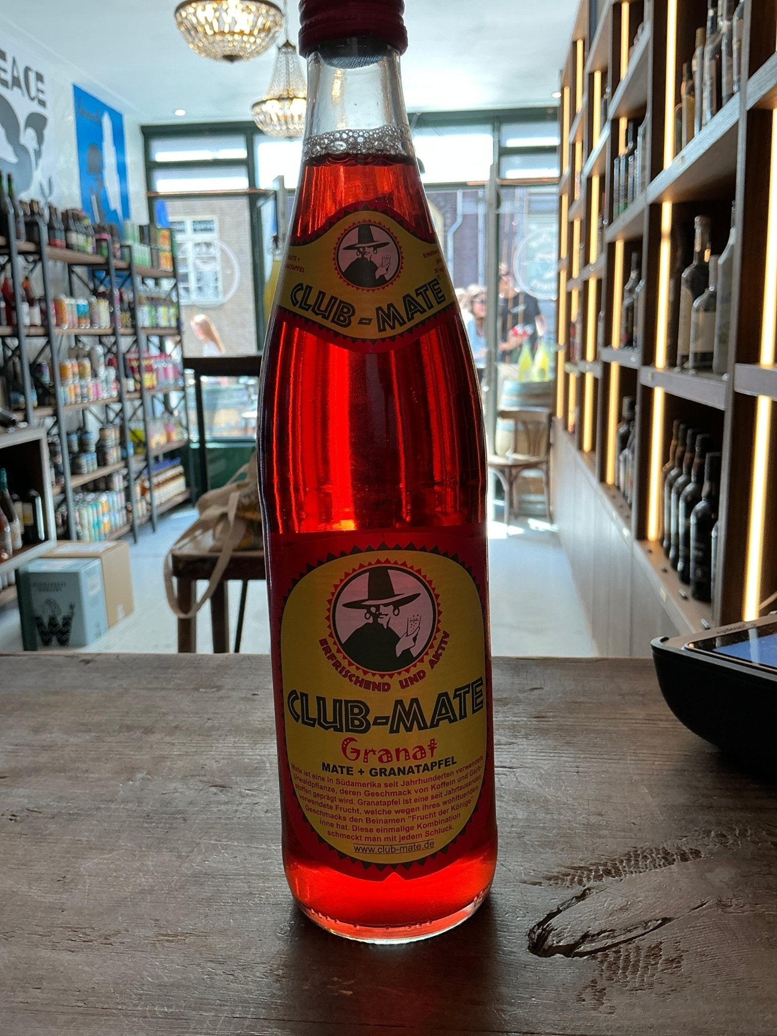 Club-Mate Granat 500ml glass bottle with deep red botanical mate infusion, premium artisan Dutch soft drink, spiced flavor.