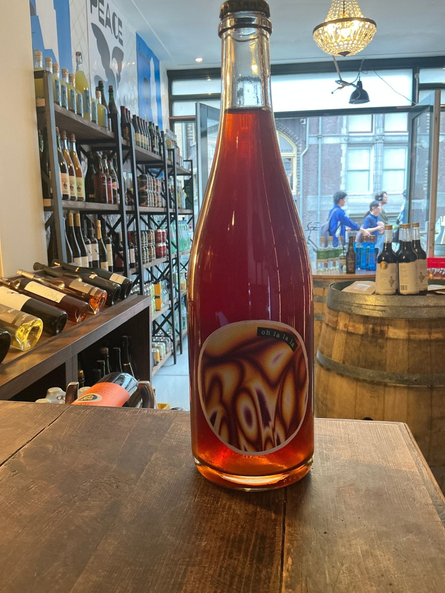 De Mederie “Oh la la la” premium barrel-aged dry cider in clear glass bottle with deep amber color and modern label on.