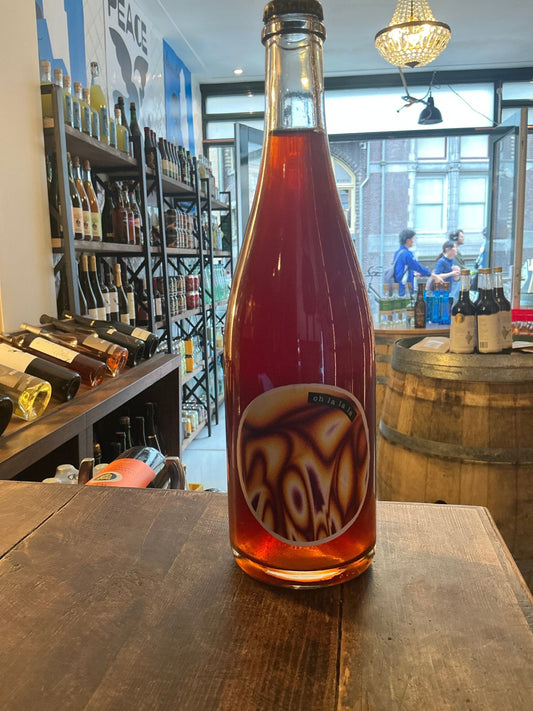 De Mederie “Oh la la la” premium barrel-aged dry cider in clear glass bottle with deep amber color and modern label on.