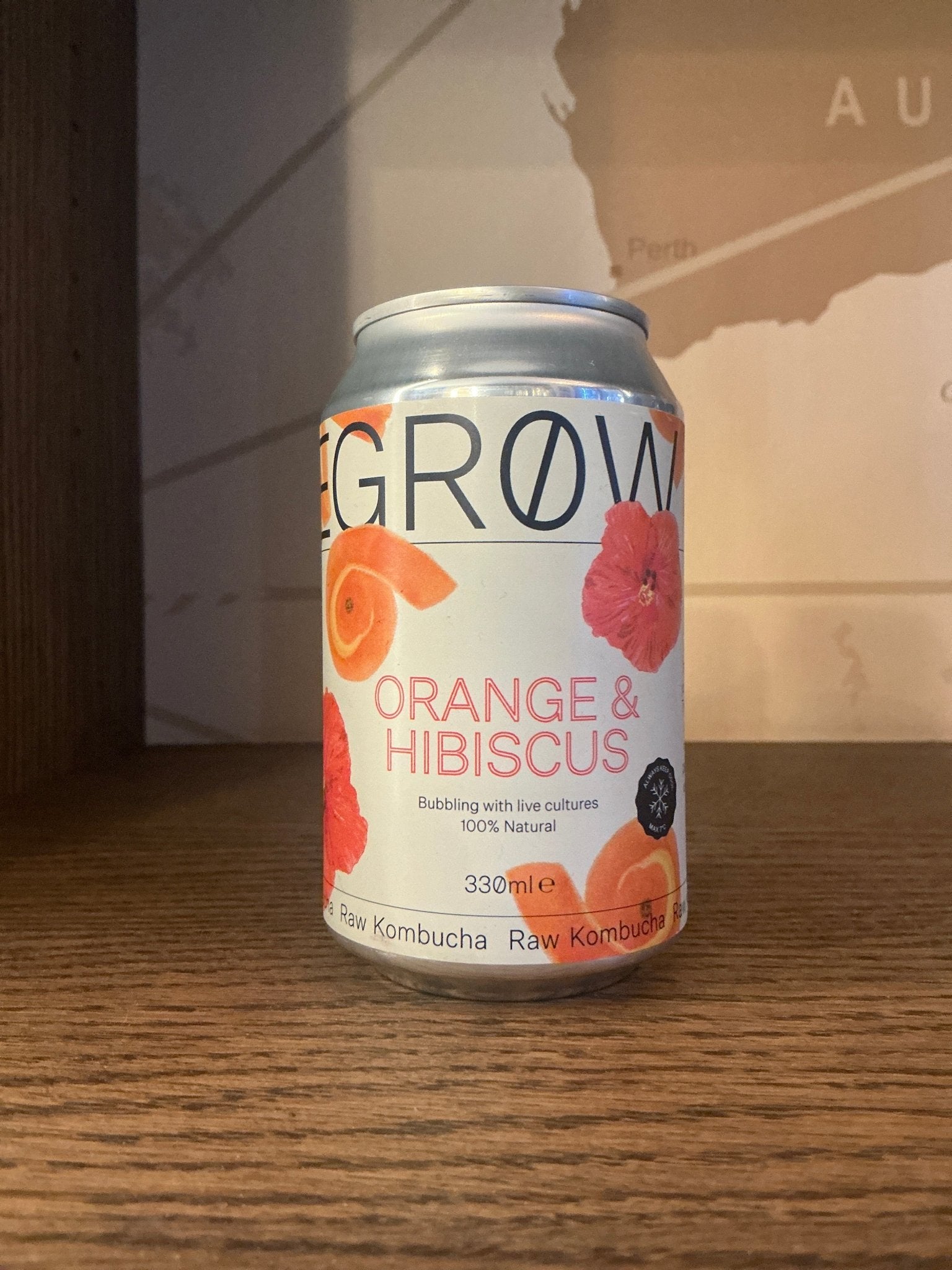 Degrow Lab De Clique Orange Hibiscus Kombucha can with white background and orange and pink floral designs, artisanal Dutch.