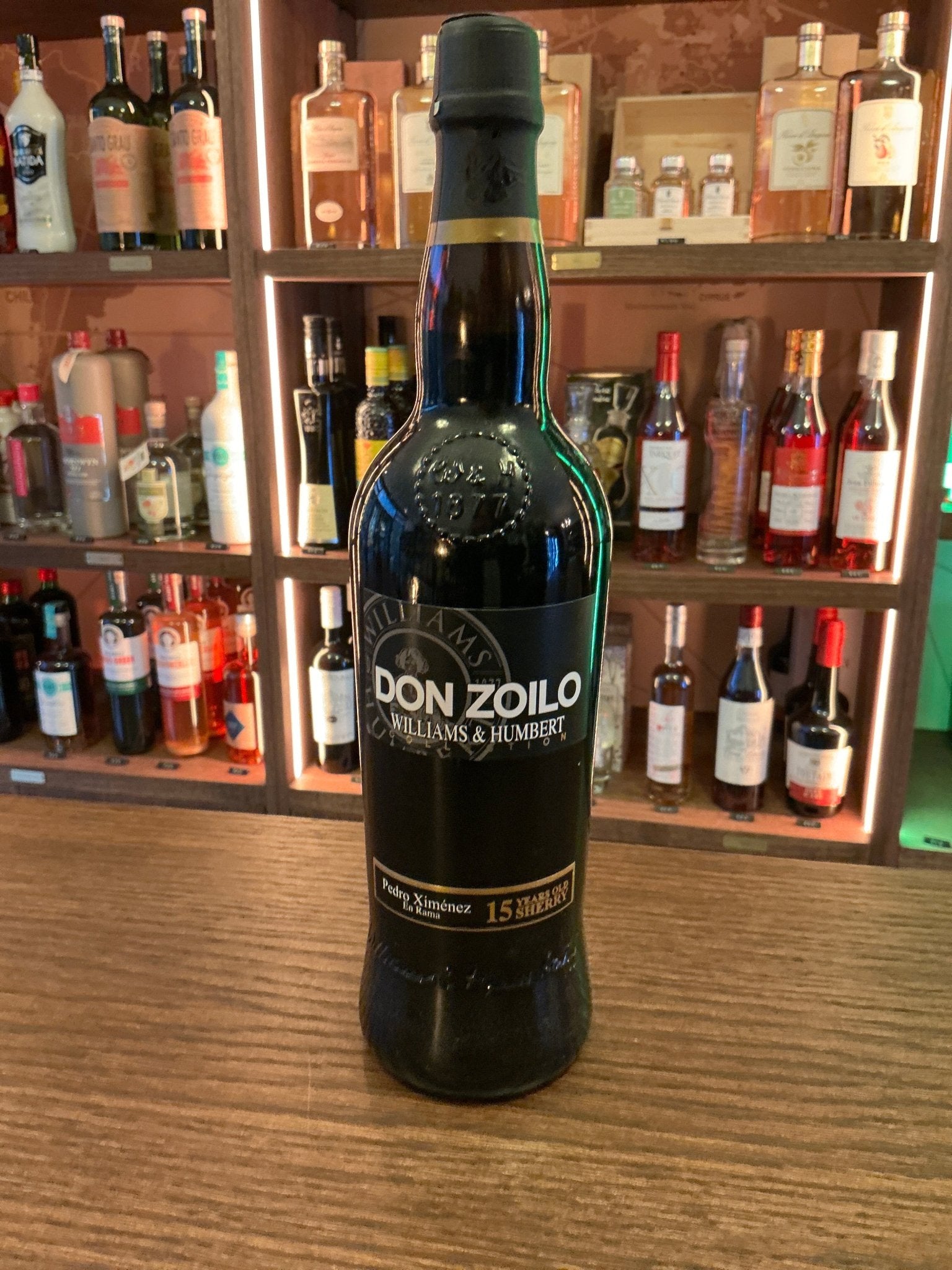 Don Zoilo Pedro Ximénez aged fortified Spanish sherry bottle on wooden bar counter with premium handcrafted spirits.